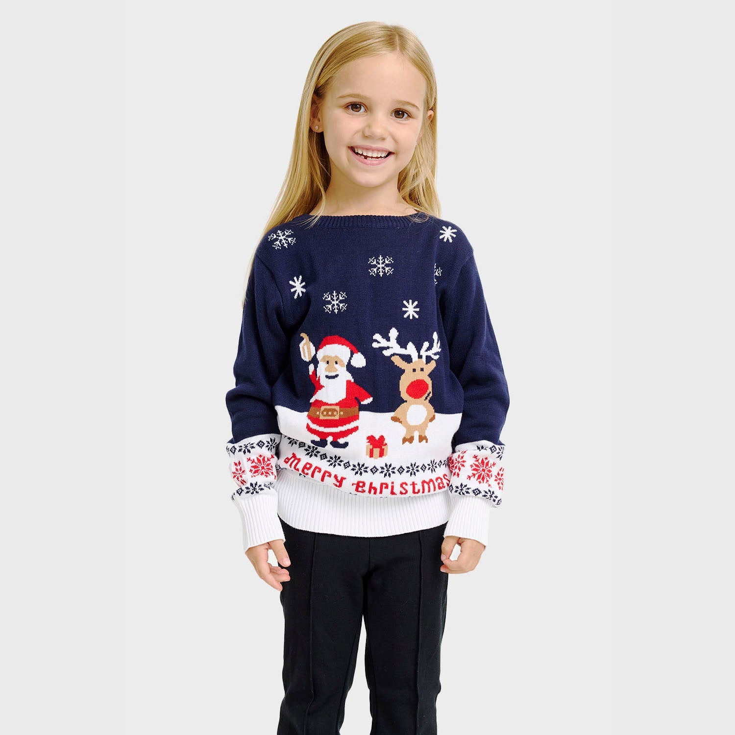 Et barn med blå julegenser med julenissen og Rudolf på.