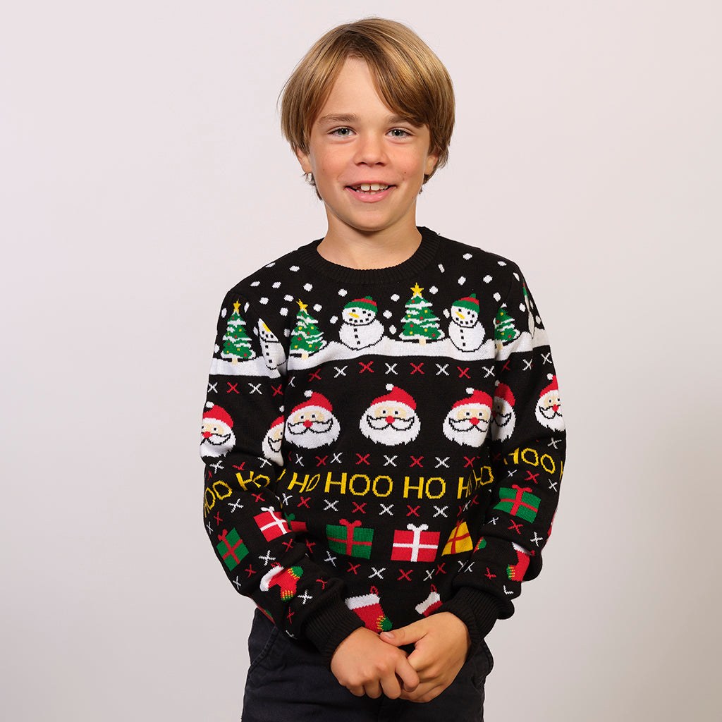 Et barn i svart julegenser med julenisse og juletrær på.