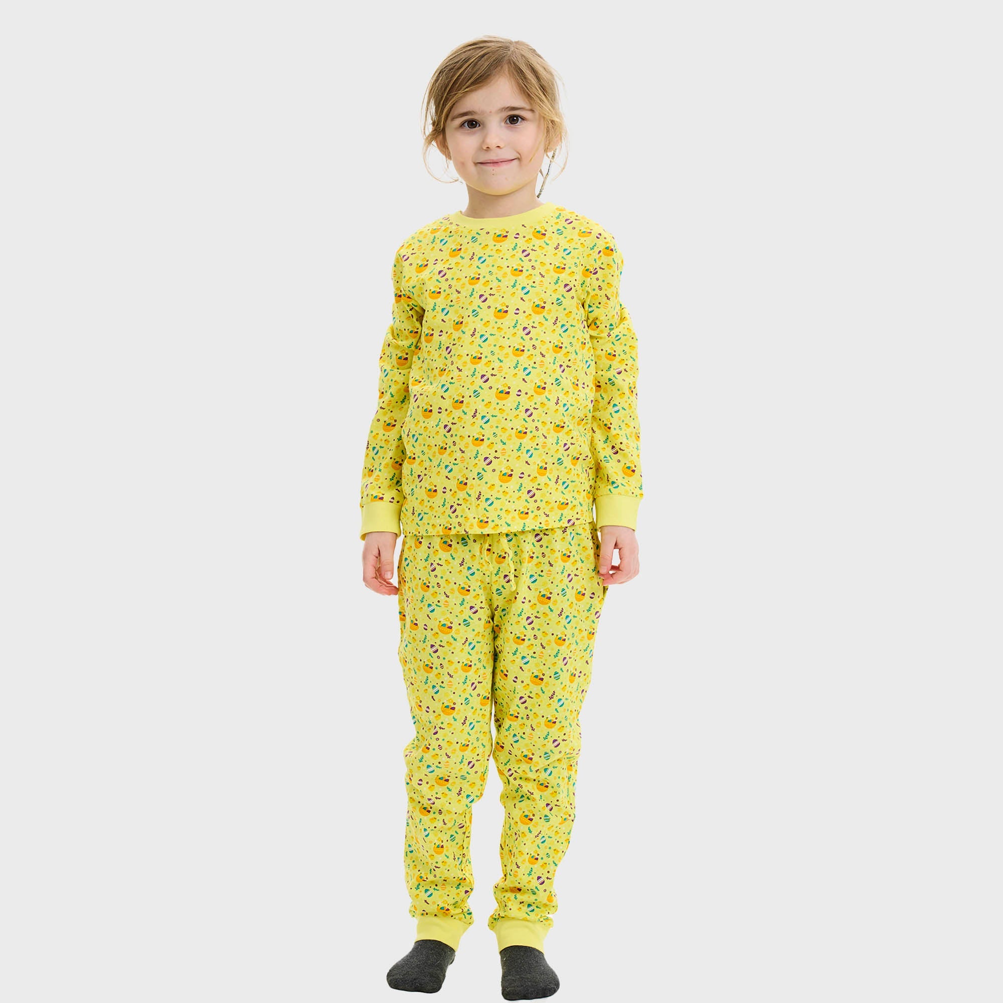 Et barn poserer i gul påskepyjamas.
