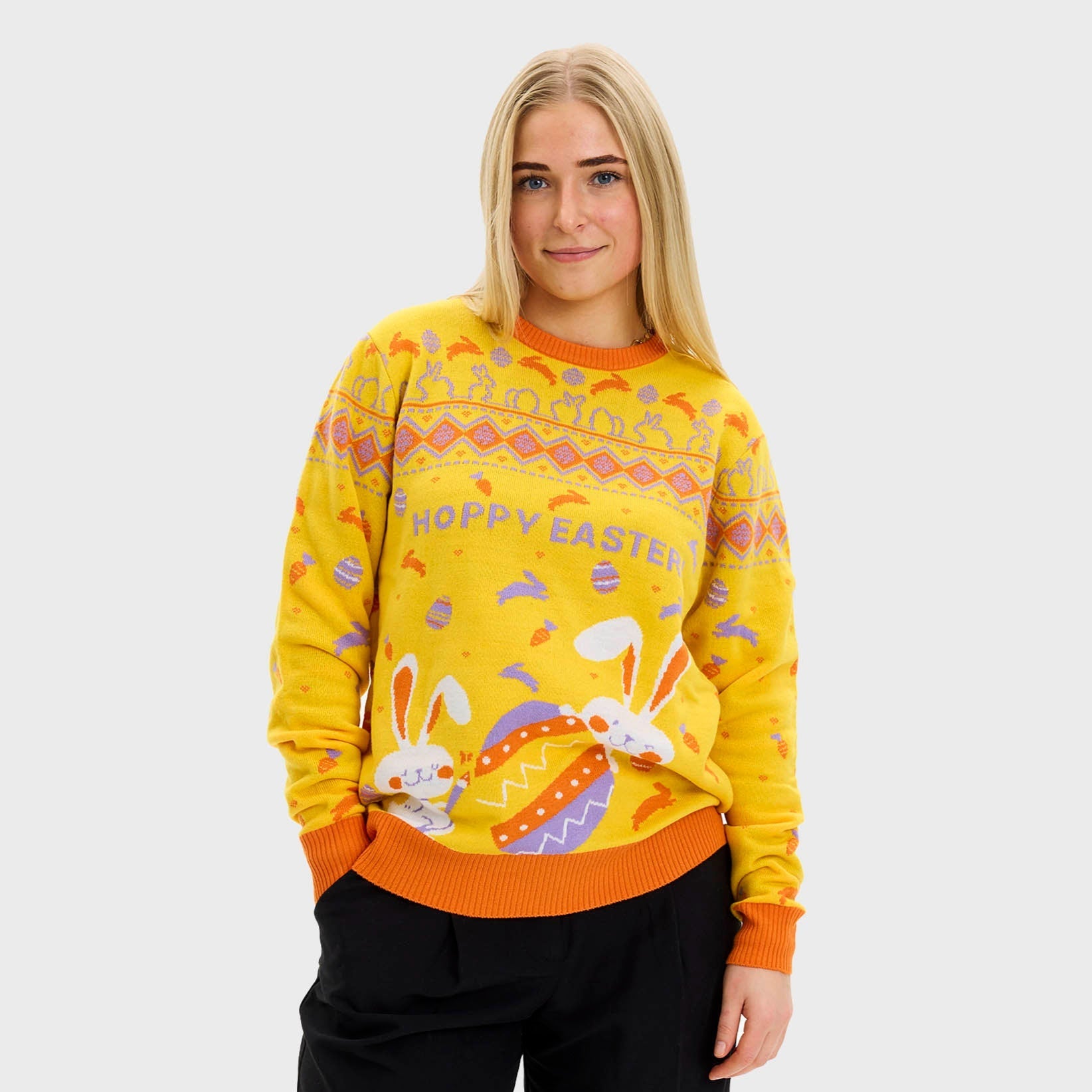 En kvinne med gul påskegenser med påskeegg på.