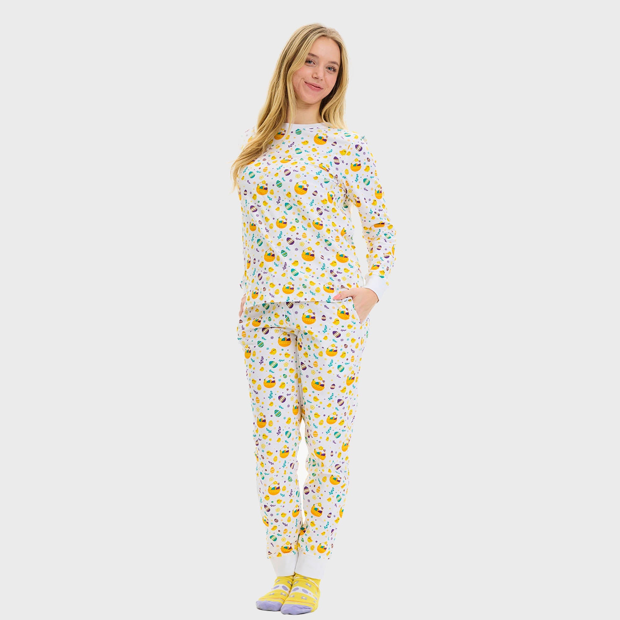 En dame holder et barn i armene, og begge har på seg en hvit påskepyjamas.