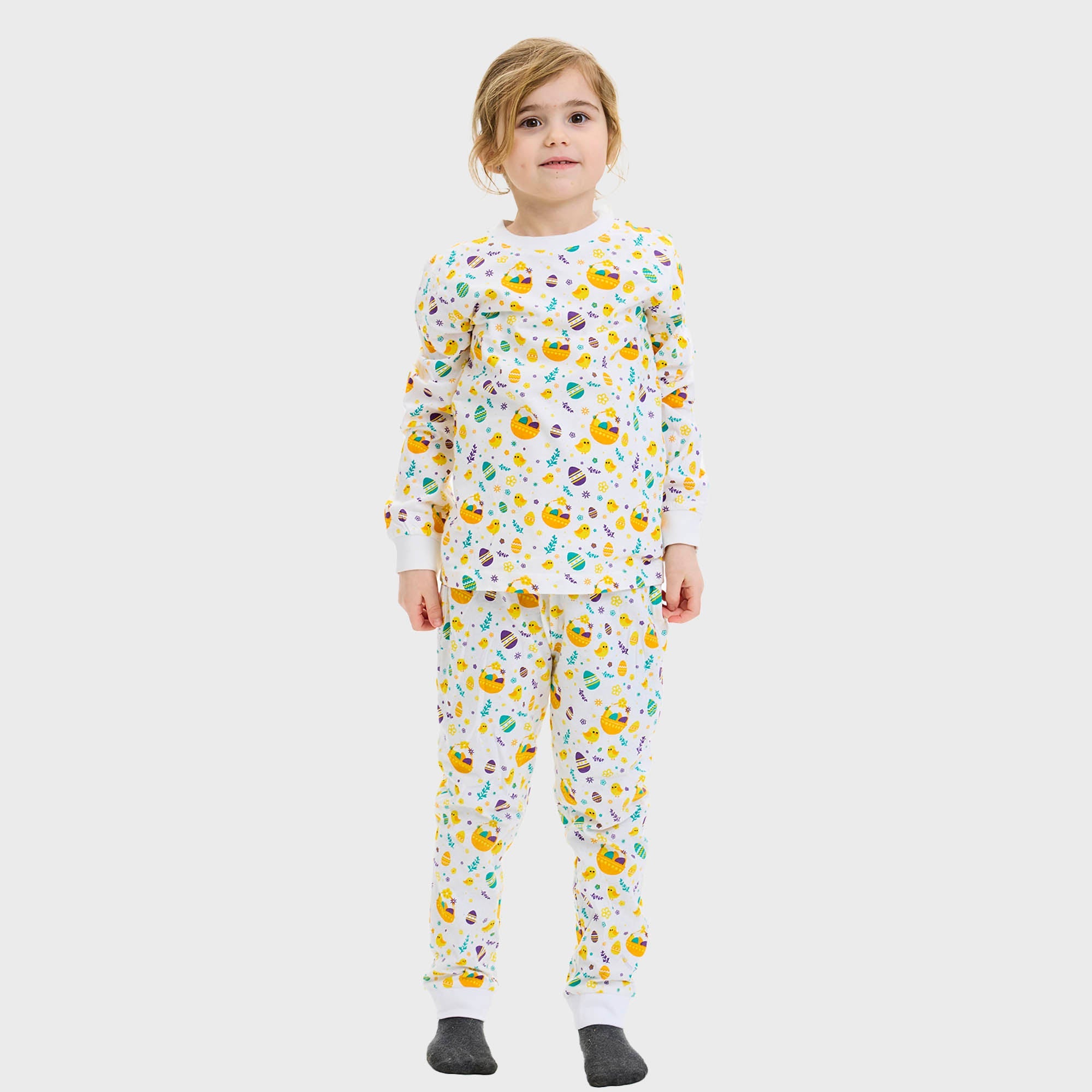 En kvinne med et barn i hvit påskepyjamas.