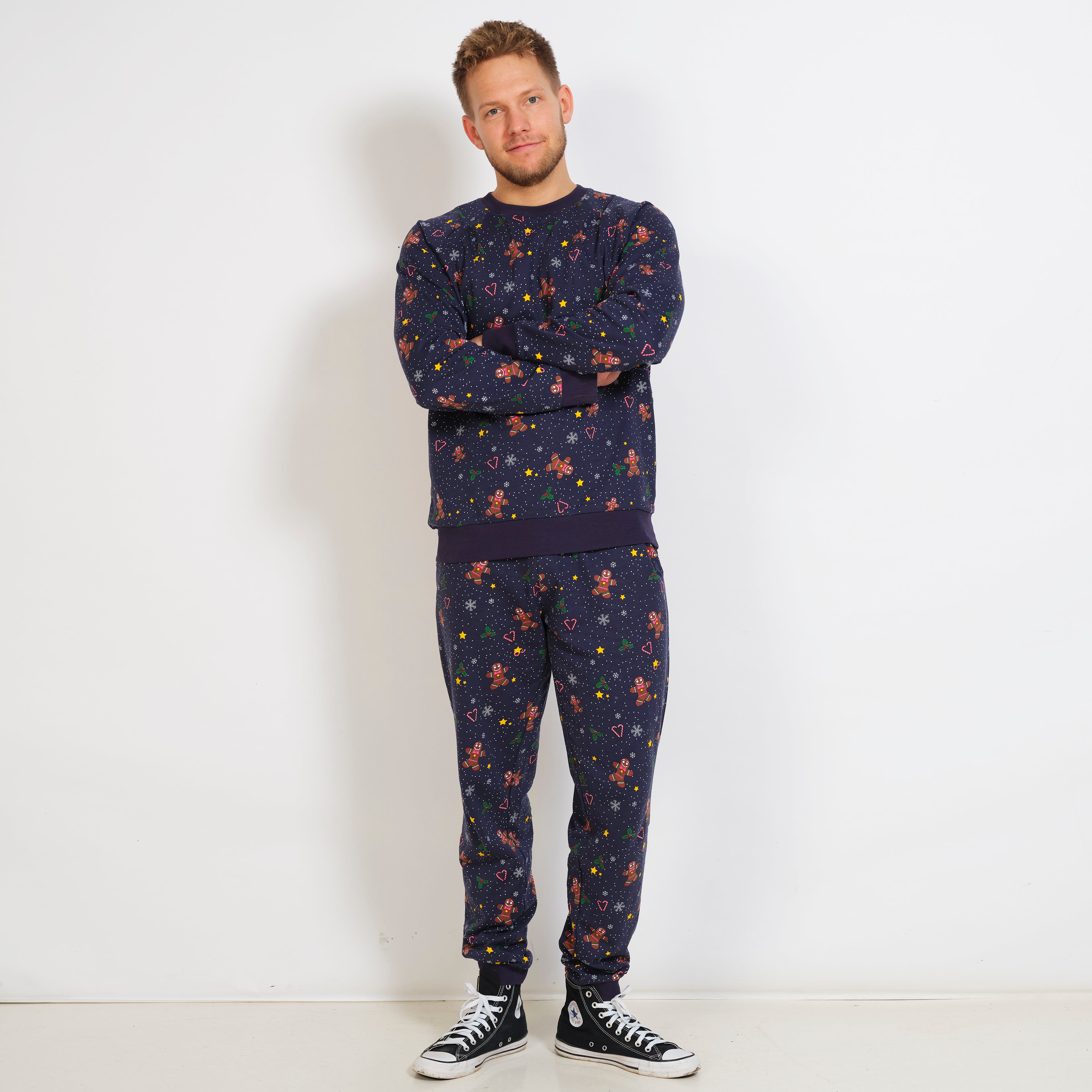 En mann har på seg en mørkeblå joggedress med mønster.