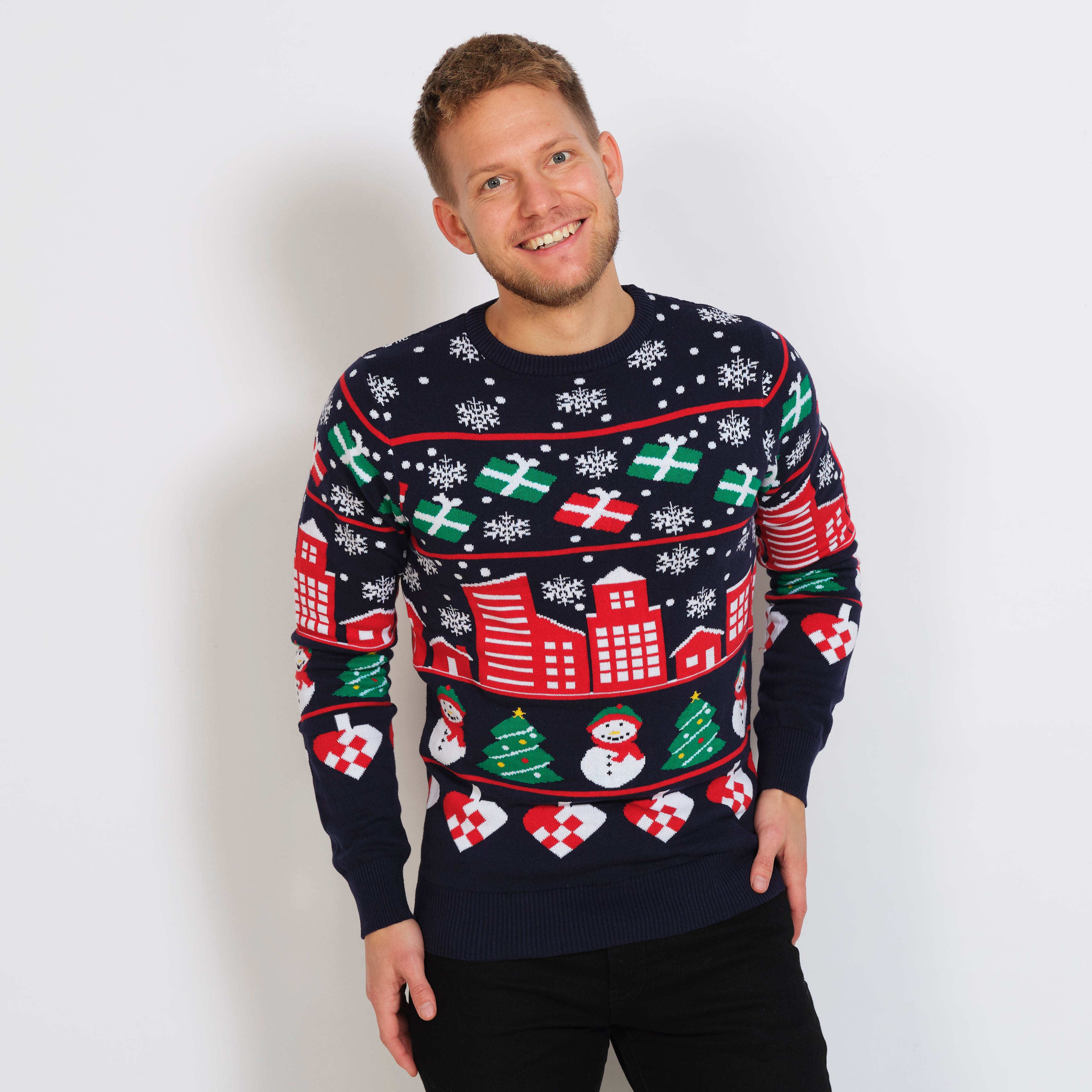 En smilende mann iført julegenser med snøfnugg og gaver.