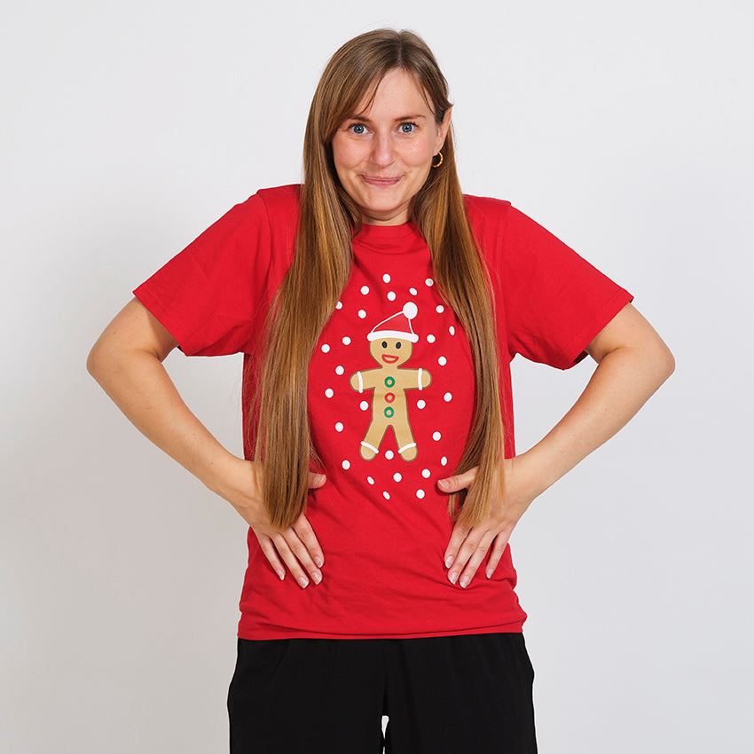 En smilende kvinne iført en rød T-shirt med en kakemann på.