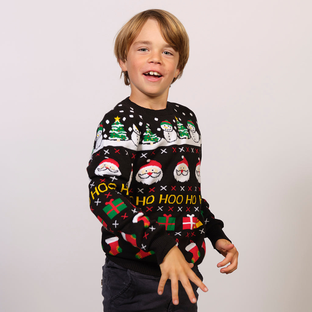 Et barn i svart julegenser med julenisse og juletrær på.