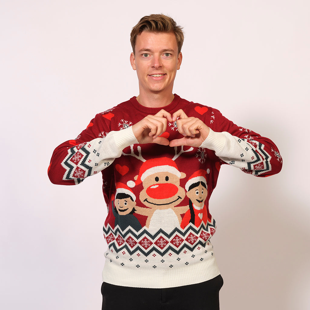 En mann i rød julegenser med barn og et reinsdyr på.