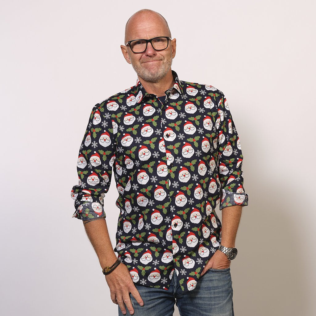 En smilende mann har på seg en fin juletrøye med trykk.