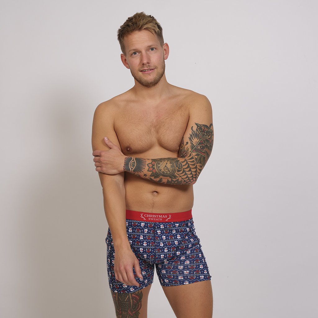 En mann har på seg en blå juleboxershorts.