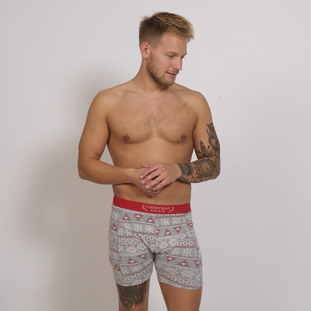 En mann har på seg en grå juleboxershorts.