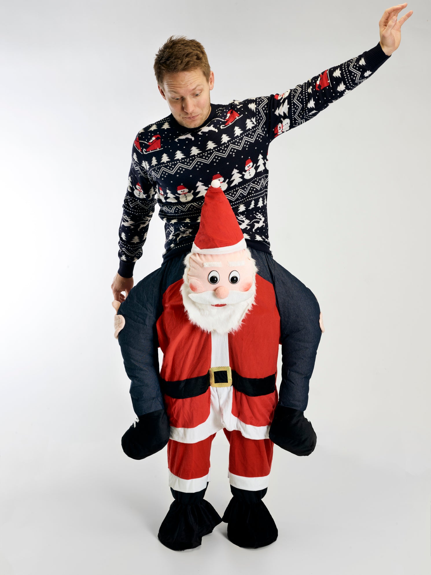 En mann i julegenser iført et carry-me-kostyme.