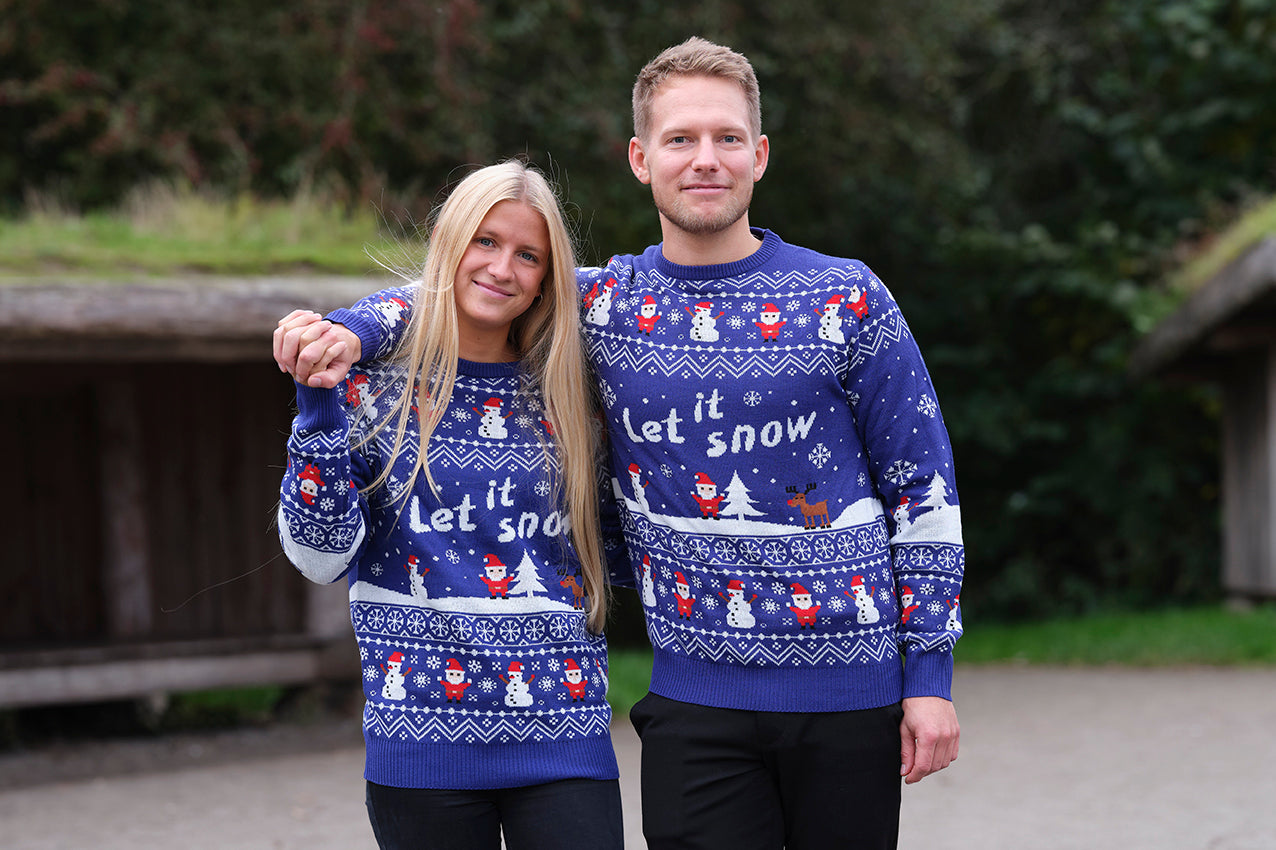 En kvinne og en mann iført en blå julegenser med sitatet 