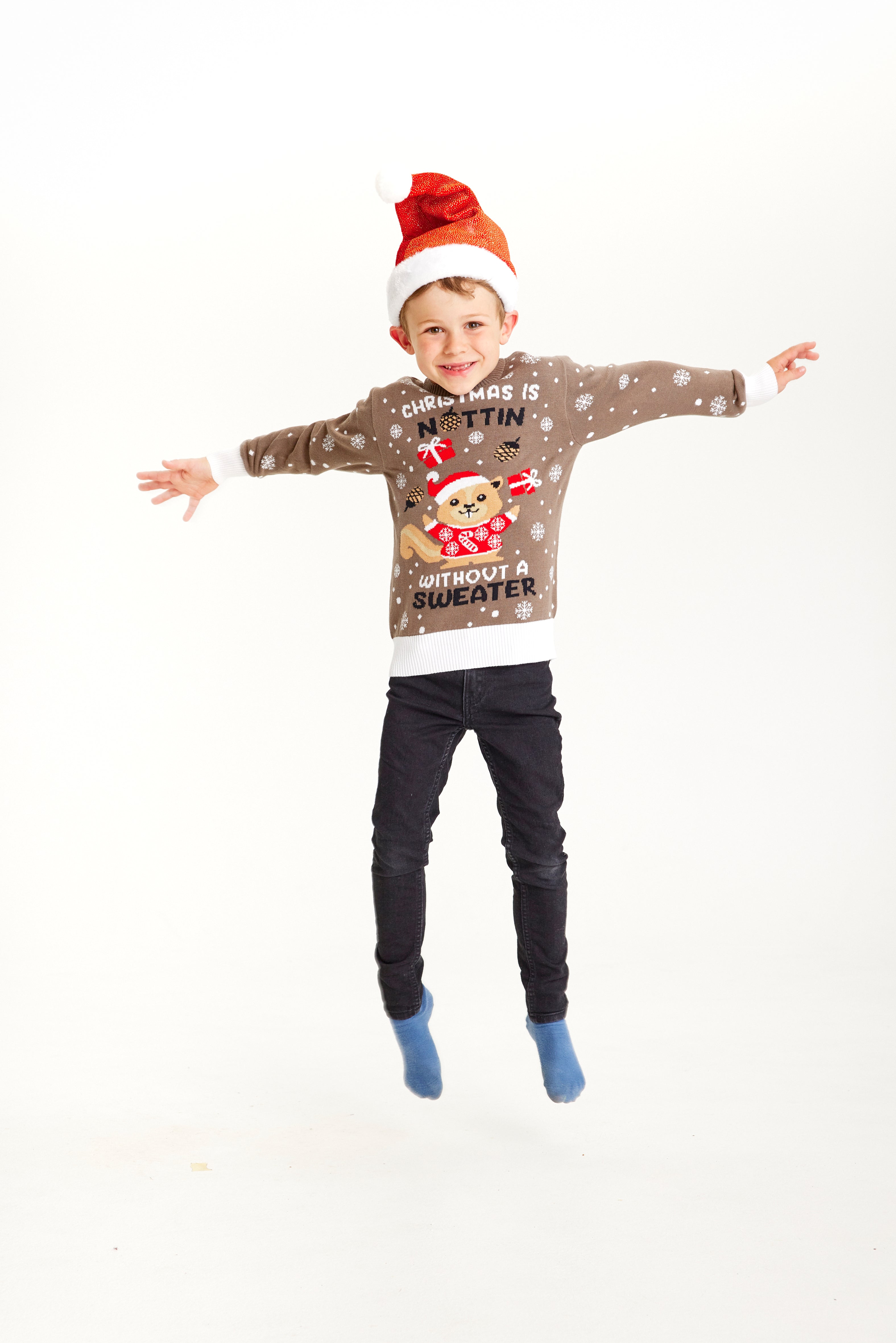 Et hoppende barn i brun julegenser med et ekorn.