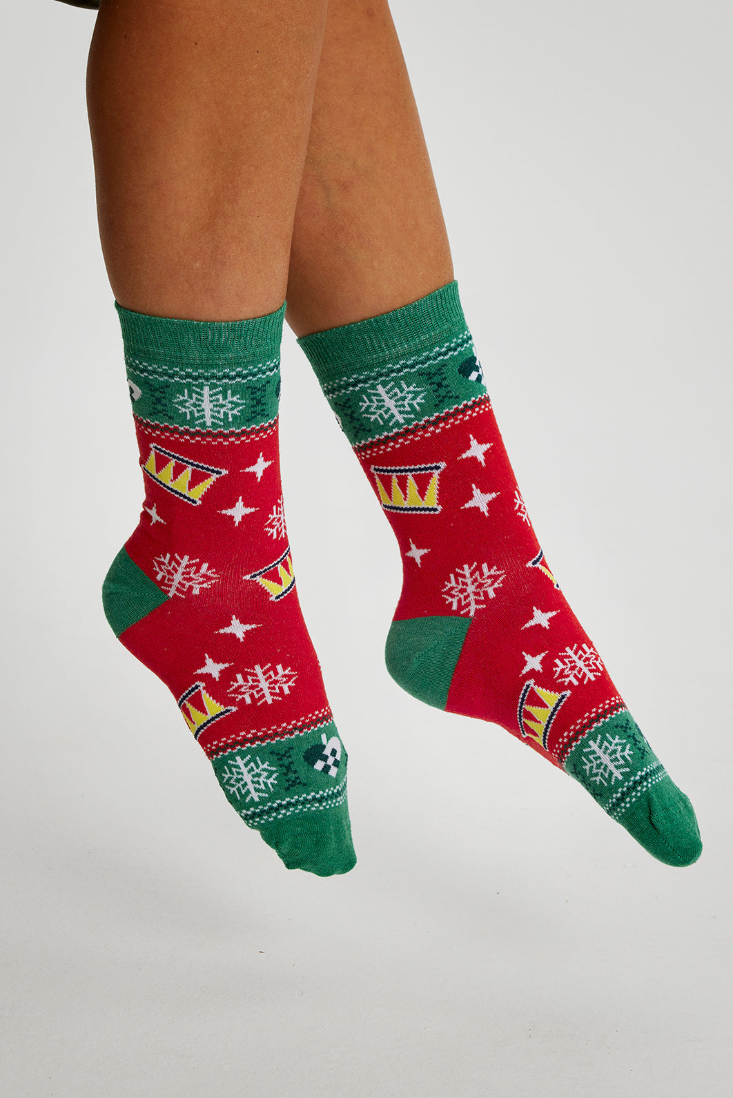 Et par føtter med røde og grønnmønstrede julesokker.