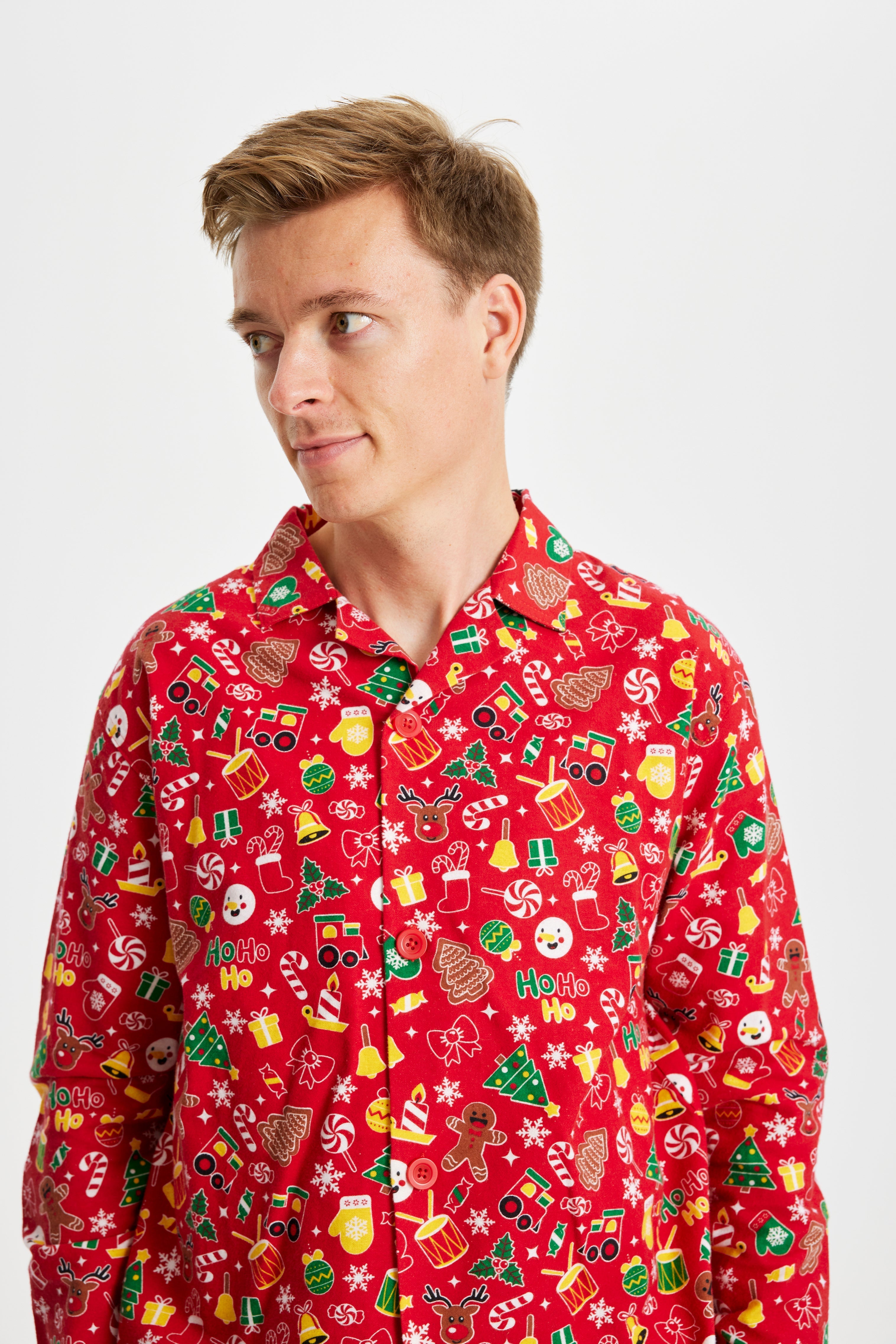 En mann ser til siden iført en rød julepyjamas.
