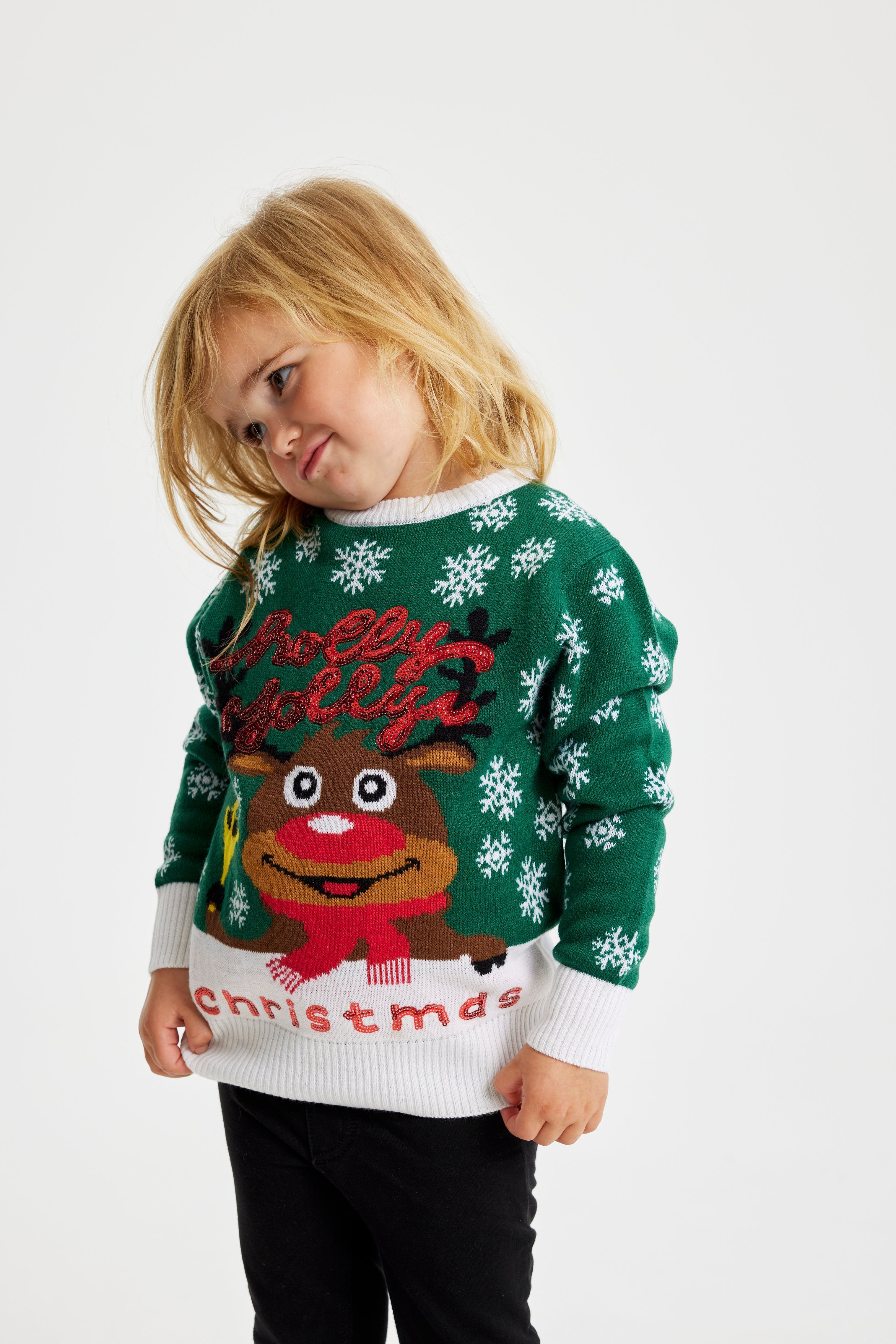 Et barn i grønn julegenser med et reinsdyr på.