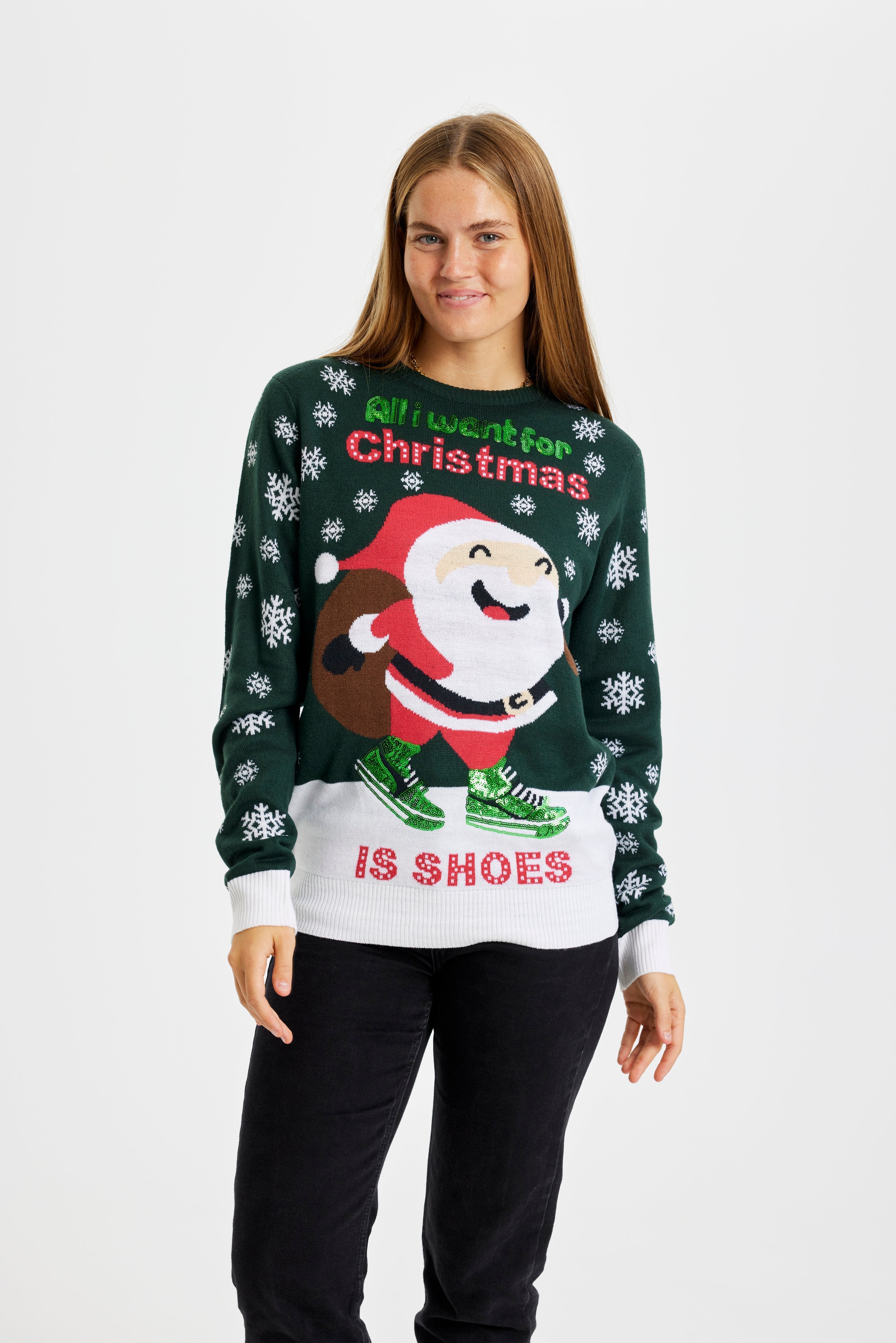 En smilende kvinne i grønn julegenser.