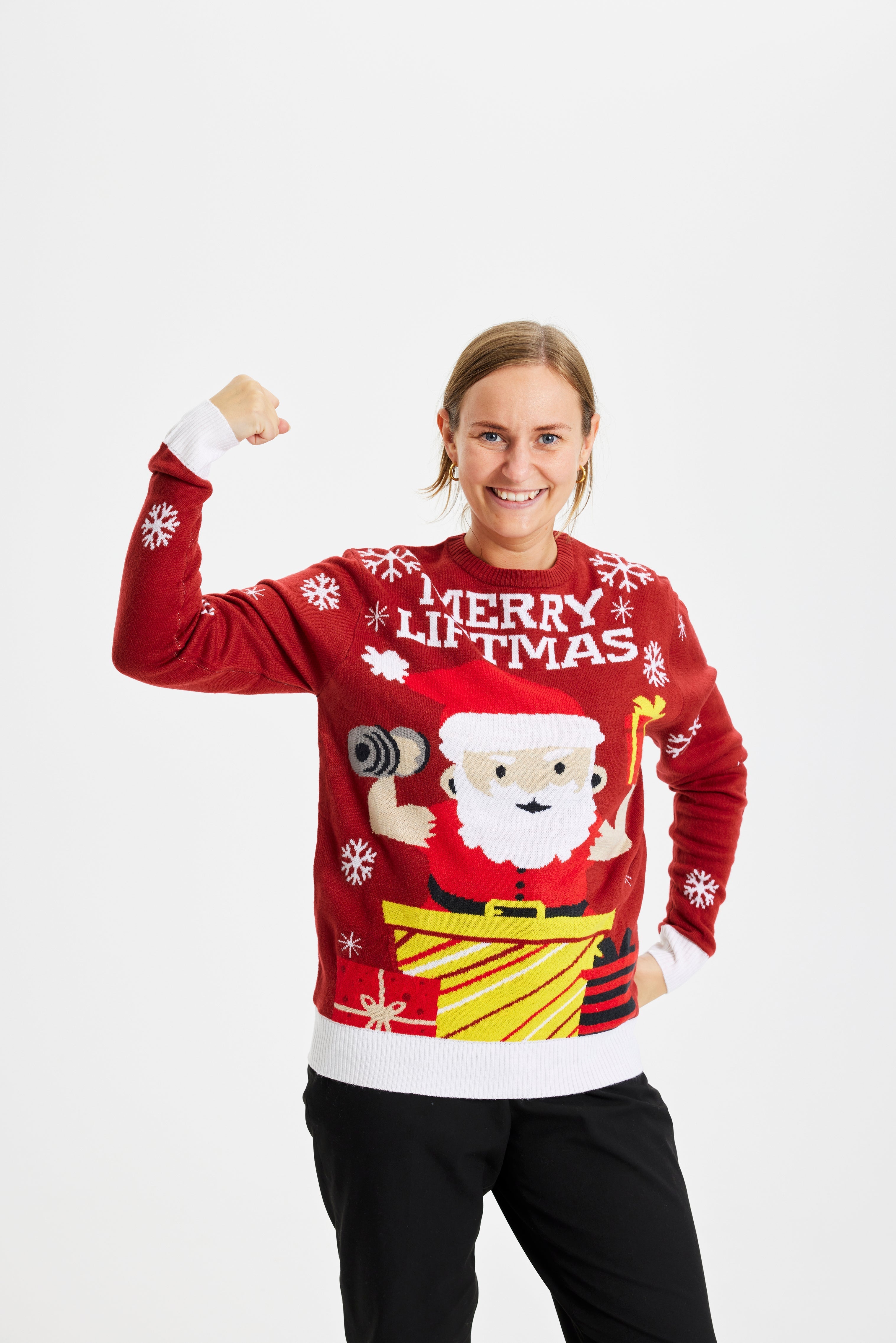 En smilende kvinne med rød julegenser med julenissen på.