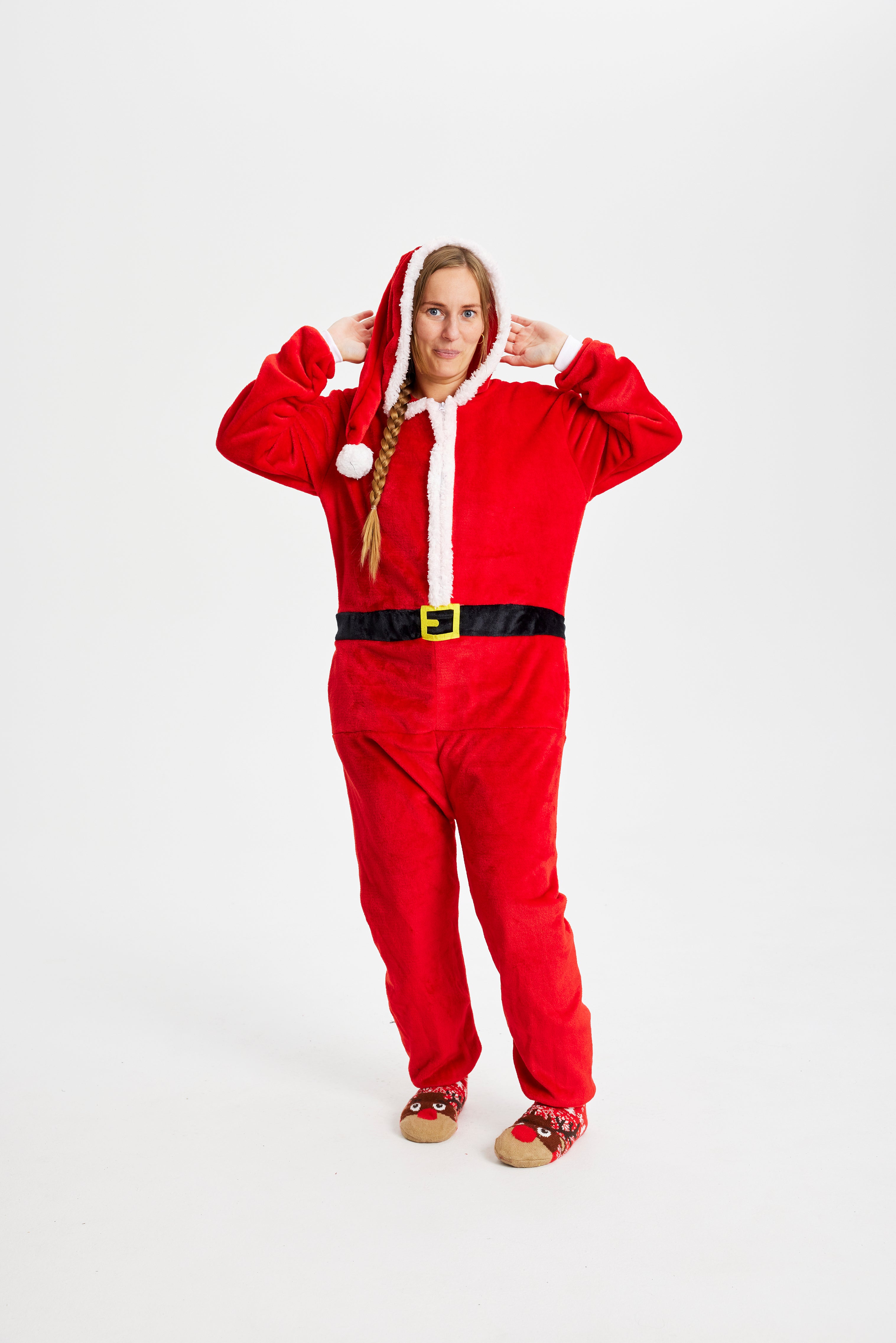 En smilende kvinne i julekostyme som ser ut som julenissen.