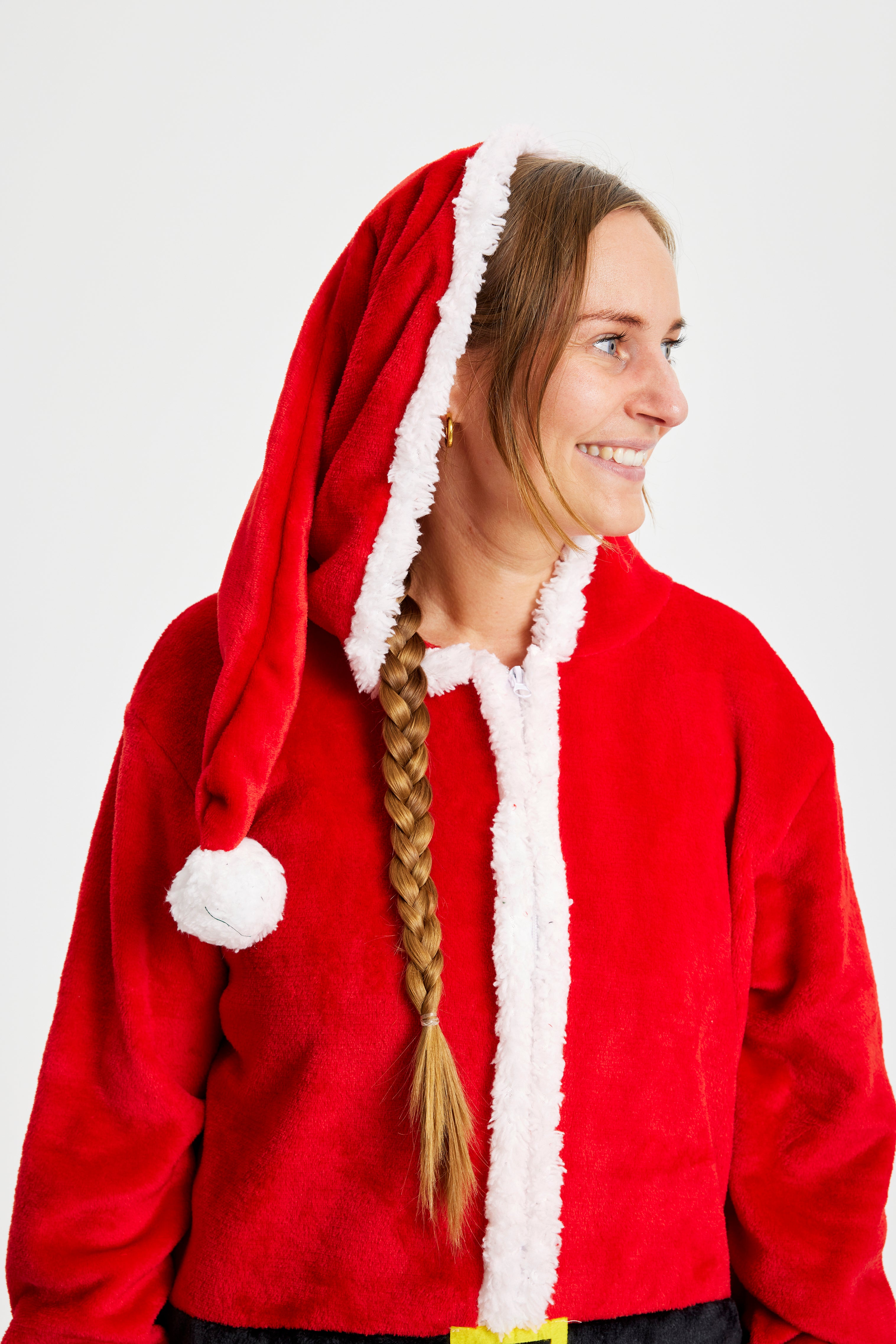 En kvinne ser til siden iført et julekostyme som ser ut som julenissen.