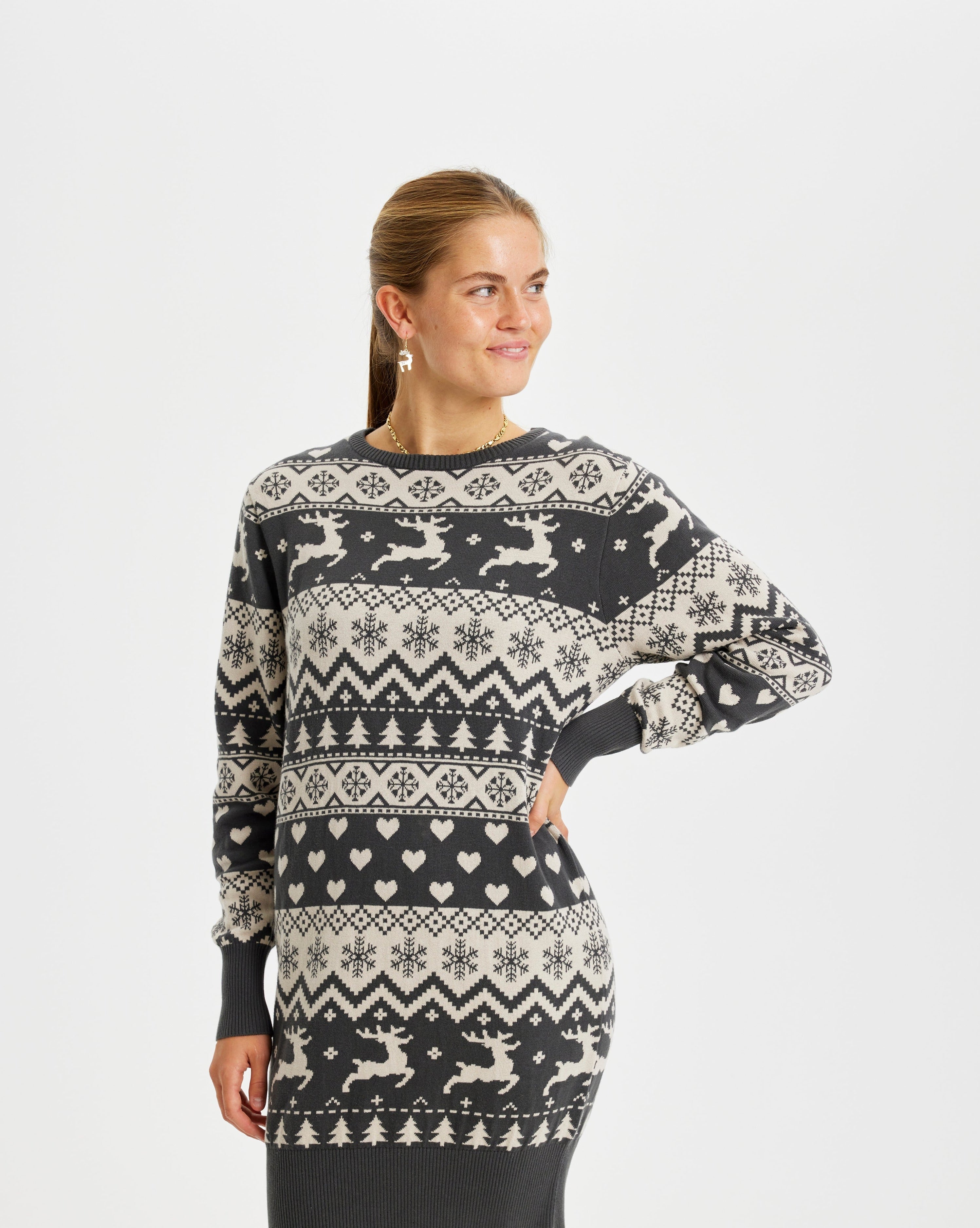 En kvinne har på seg en strikket julekjole med reinsdyr på.