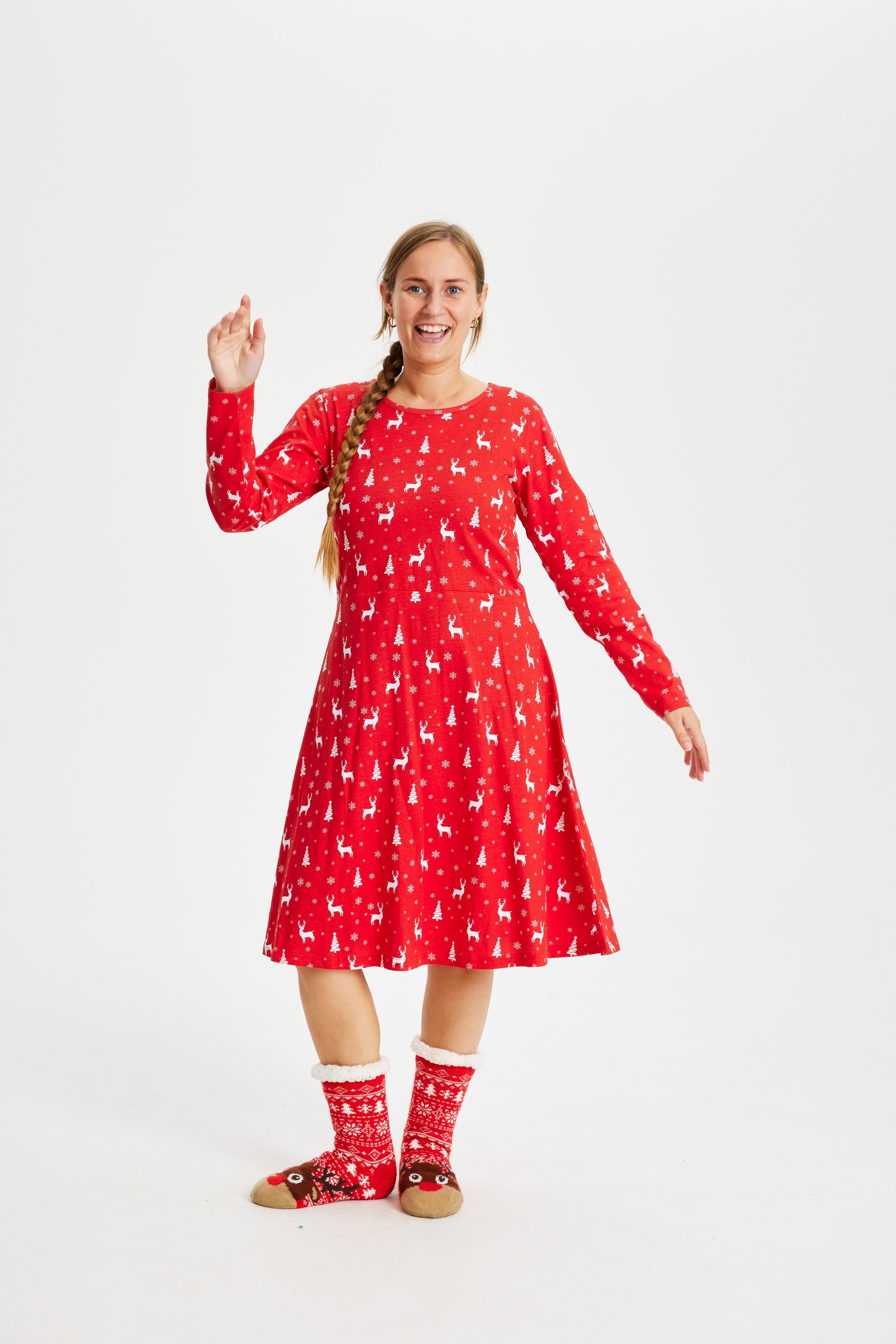 En kvinne i rød julekjole med reinsdyr på.