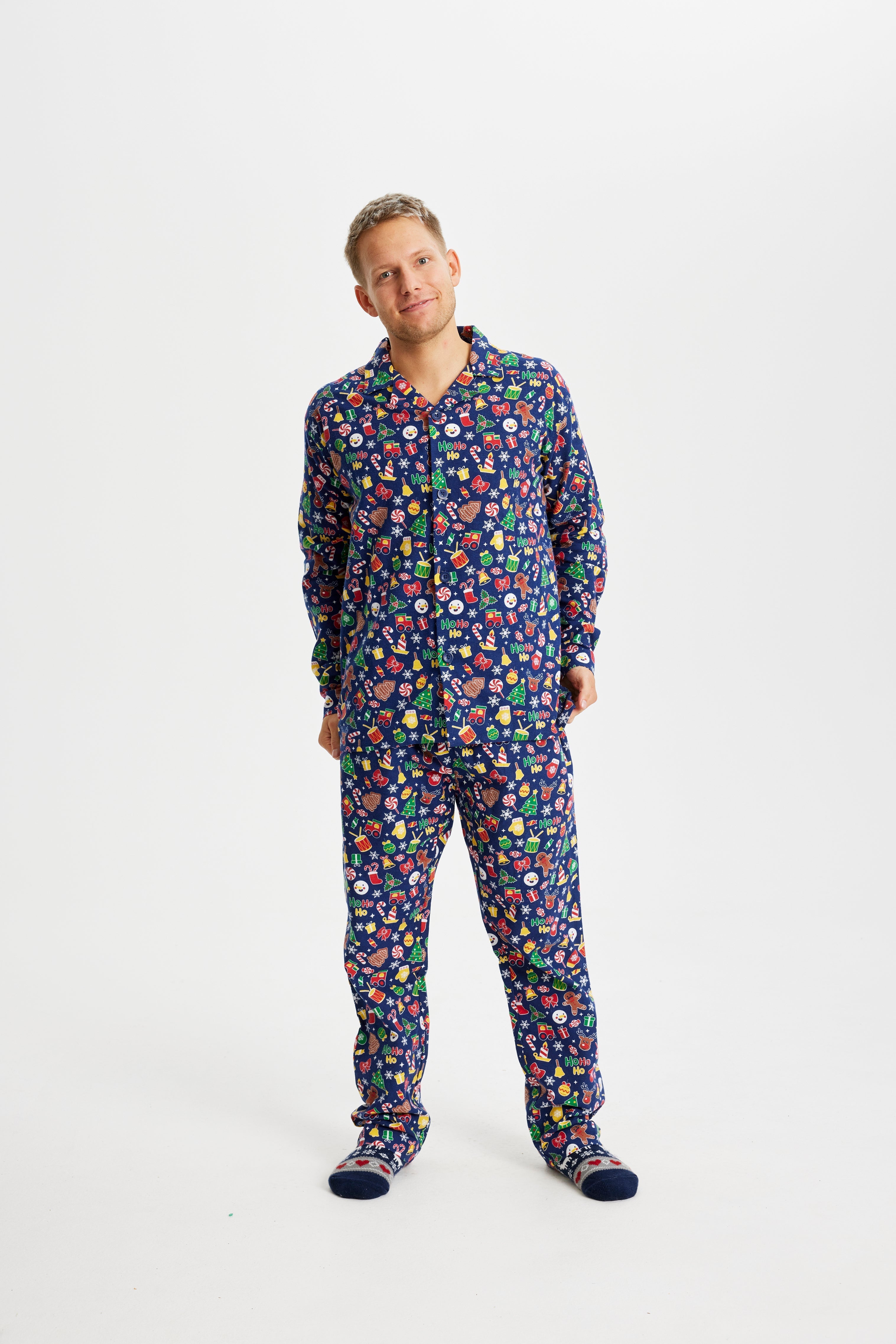 En smilende mann i blå julepyjamas.