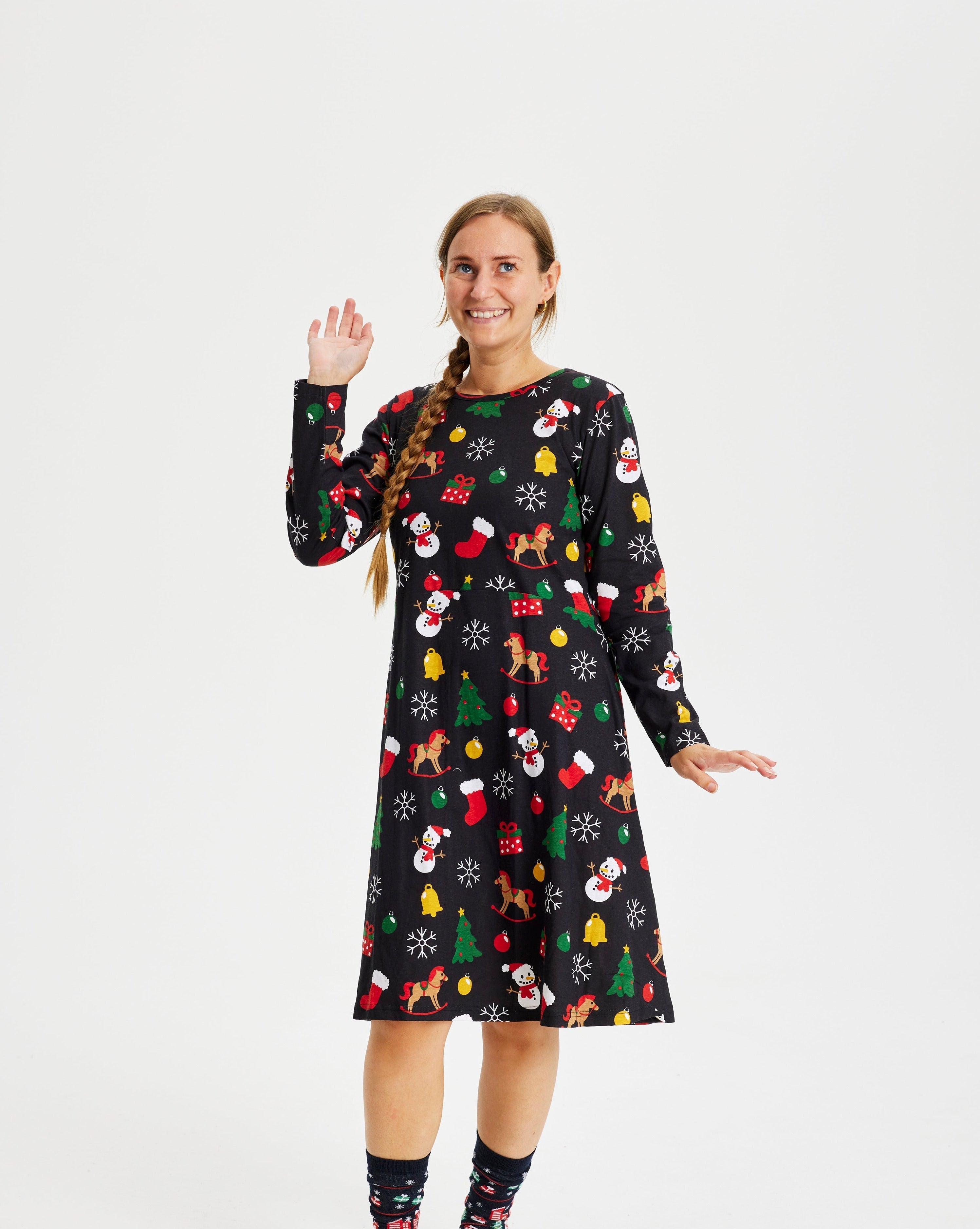 En kvinne har på seg en svart julekjole med nisseluer.