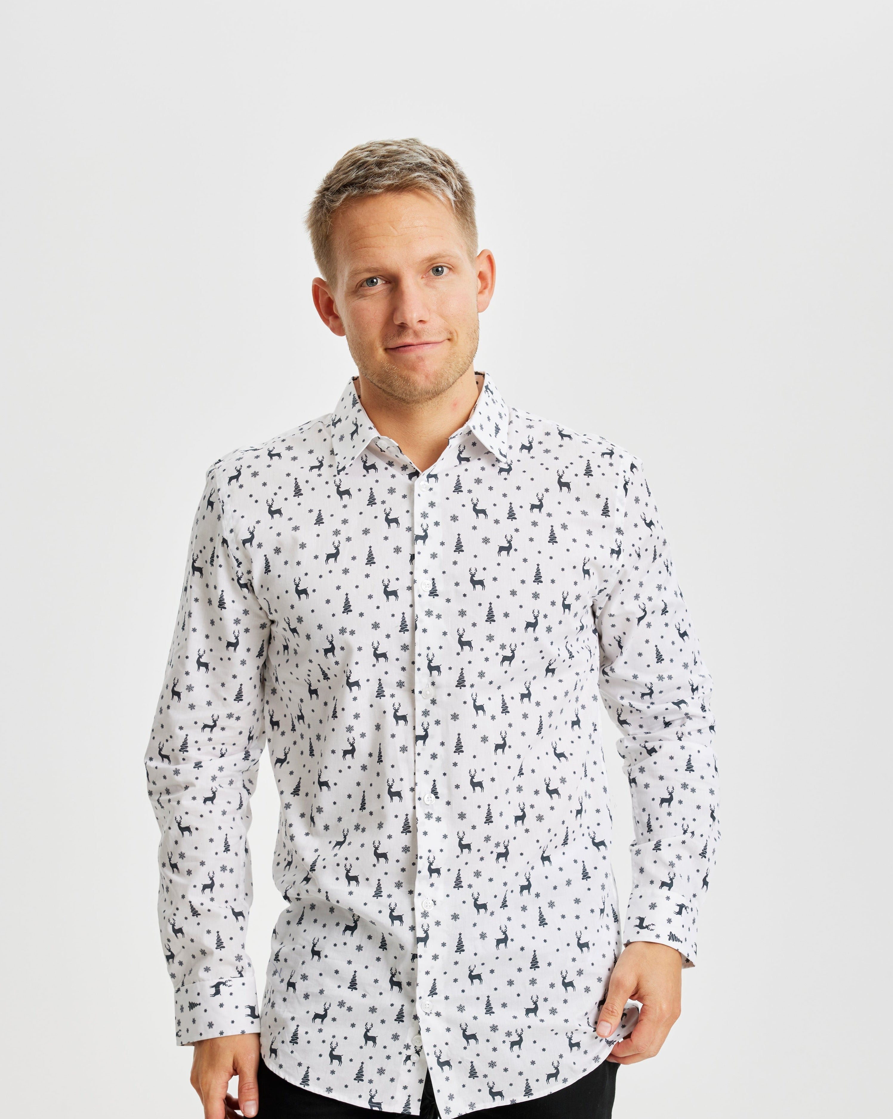 En smilende mann i hvit juletrøye.