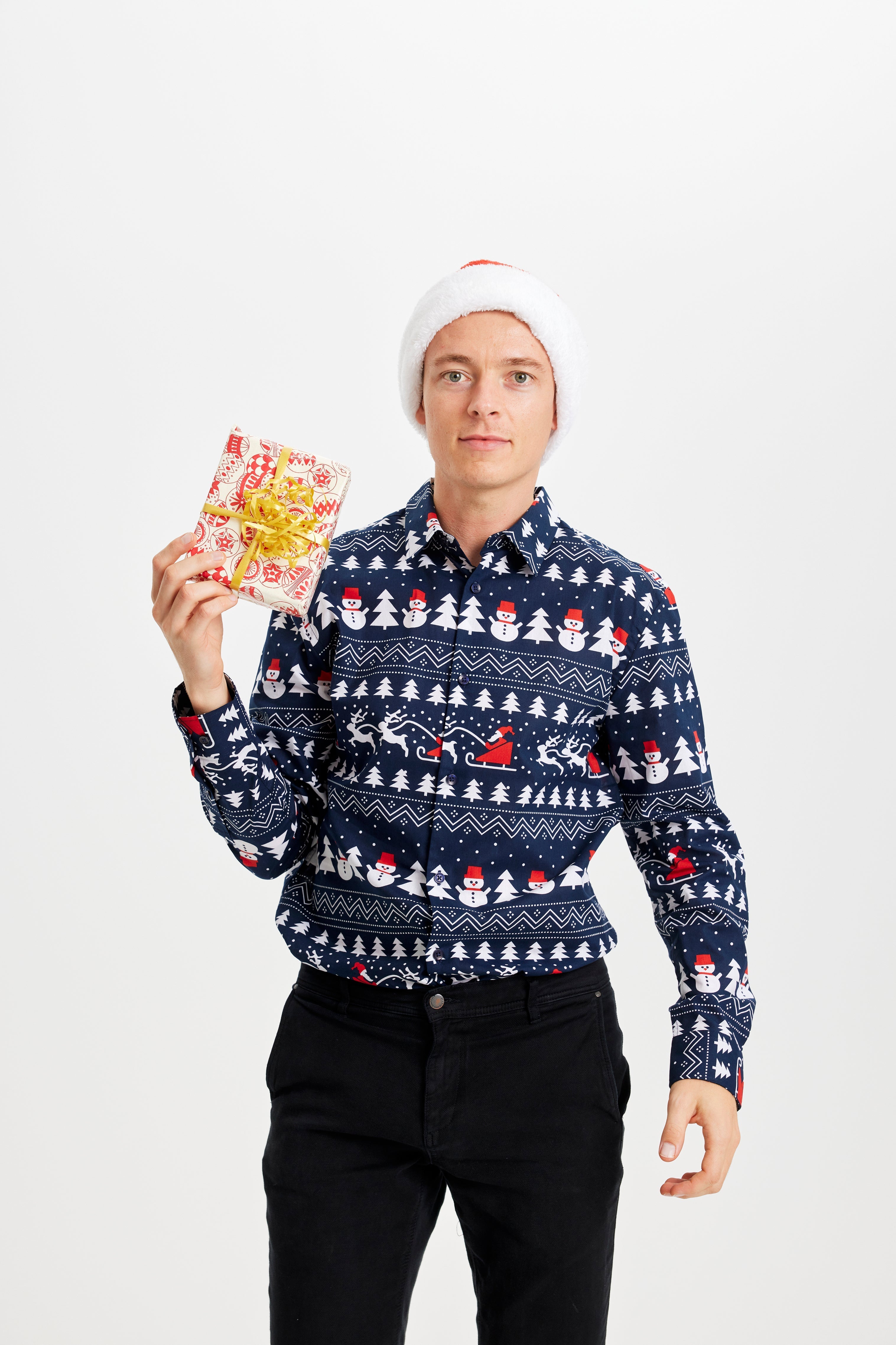 En mann med en gave har på seg en blå juletrøye.