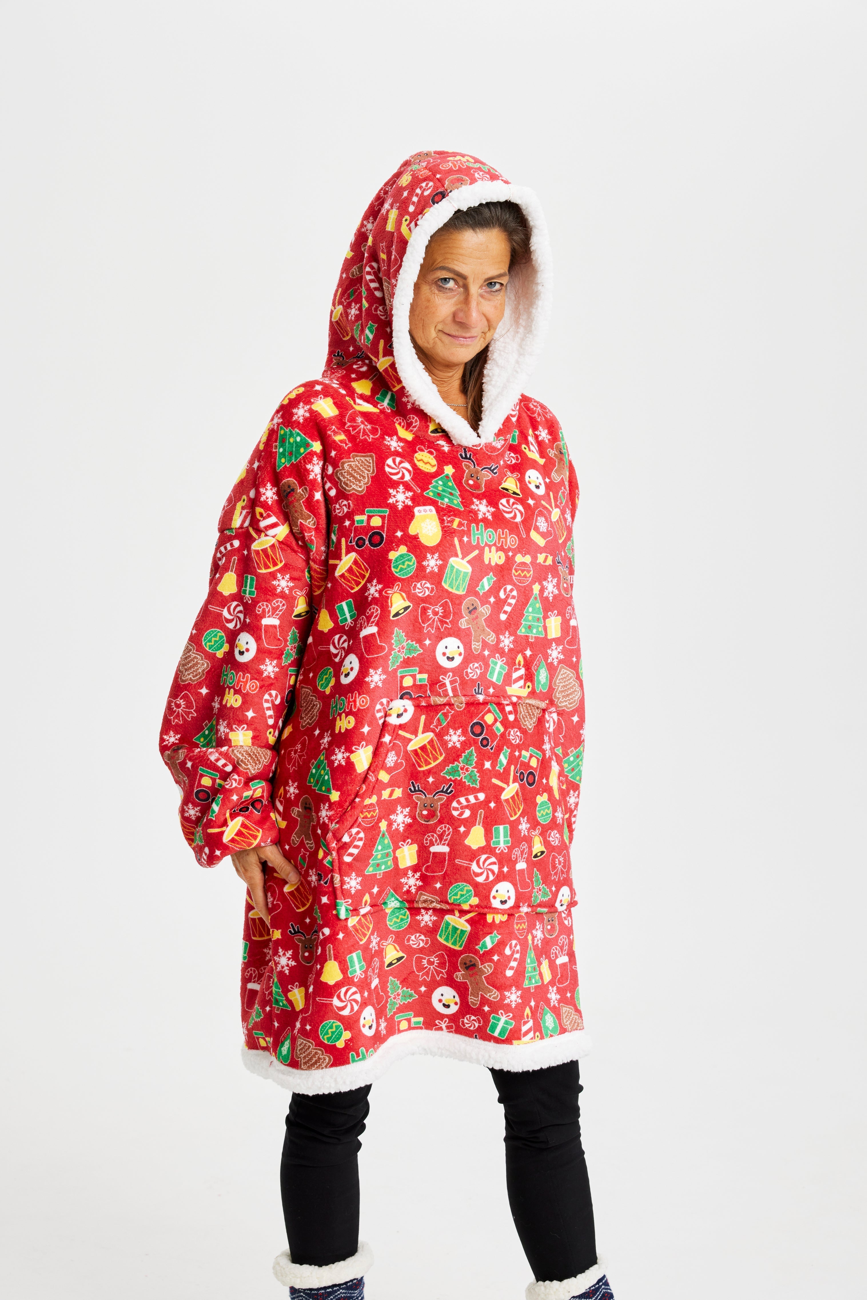 En dame med hette iført en rød julehettegenser med julemønster.