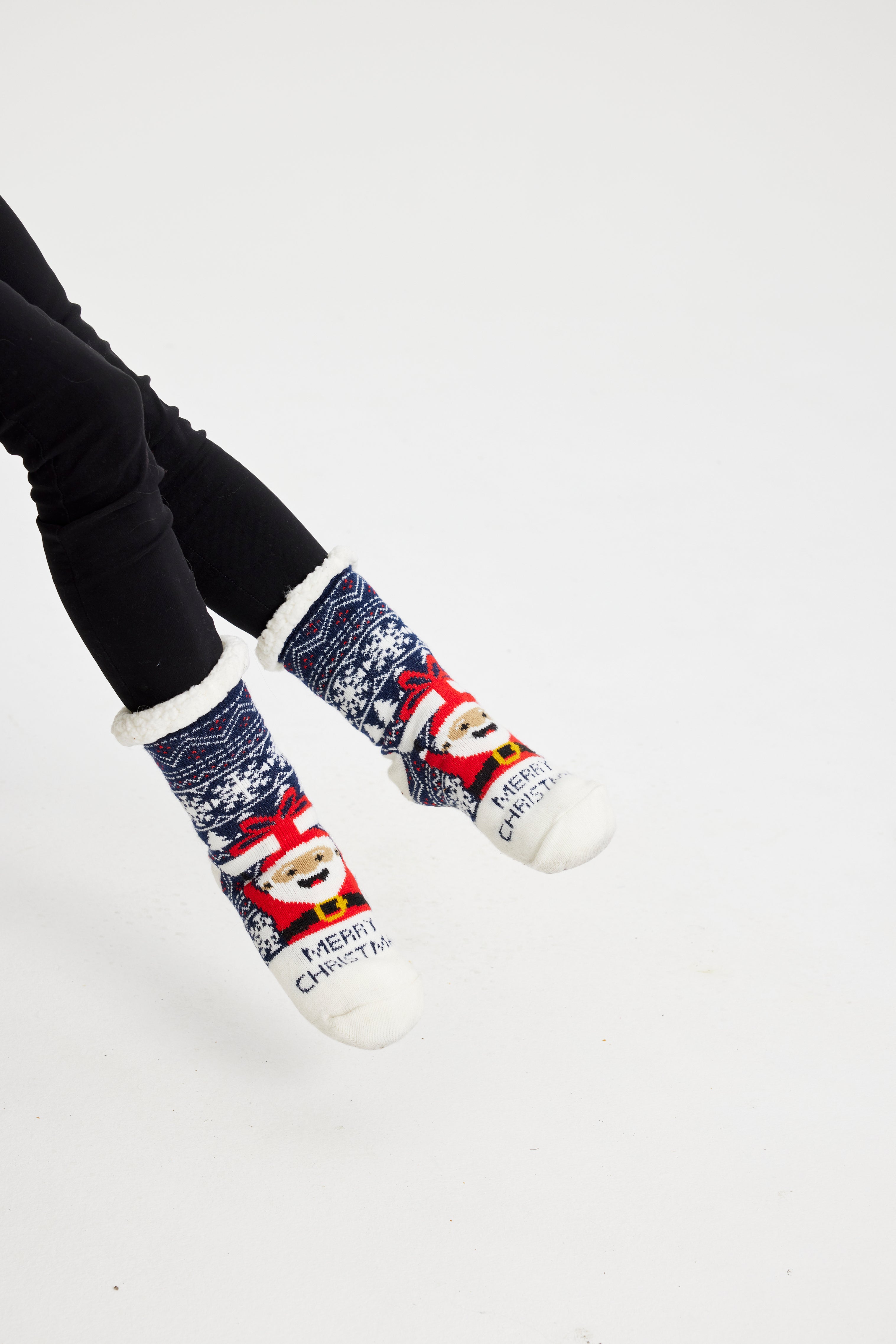 Et par føtter iført julesokker med julenissen på.