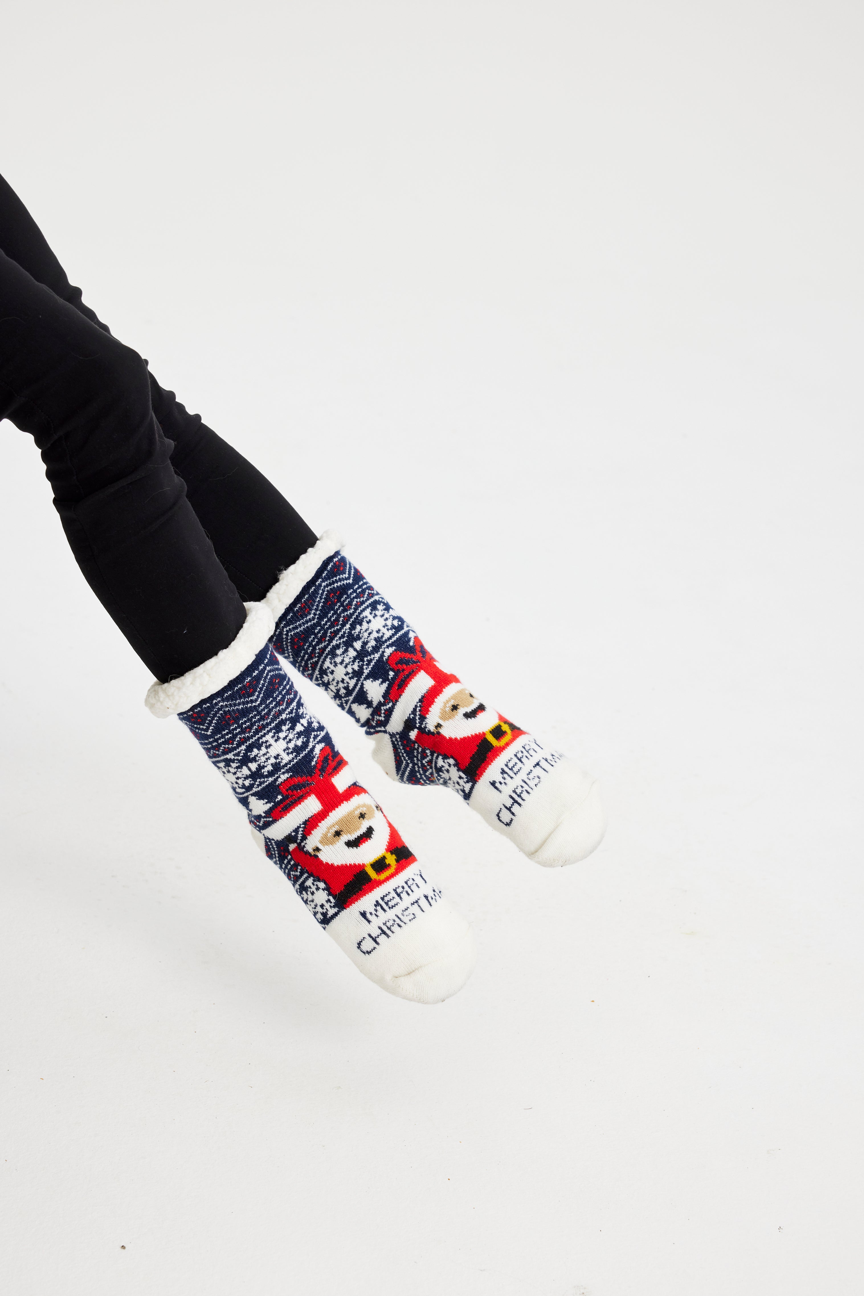 Et par føtter iført julesokker med julenissen på.