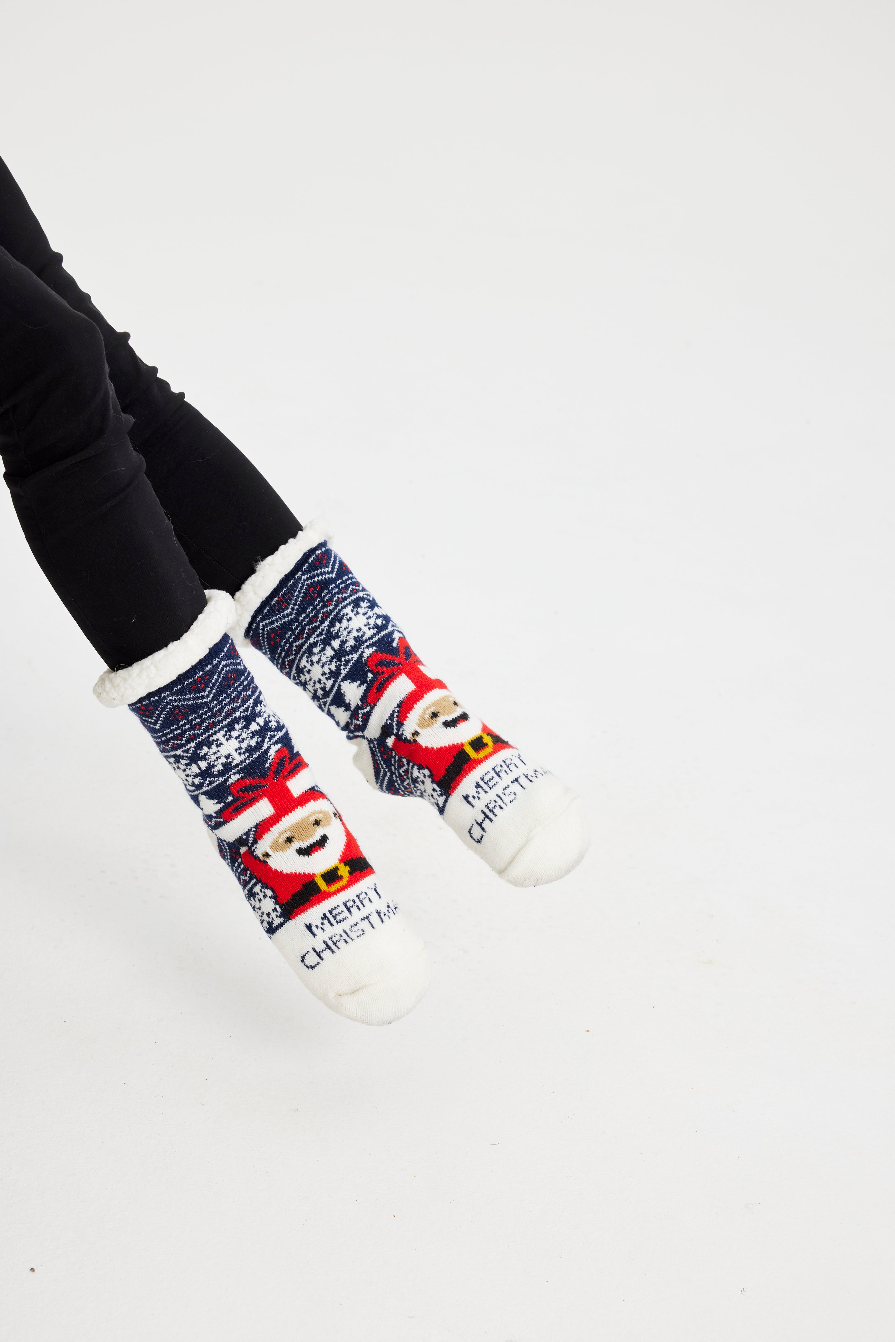 Et par føtter iført julesokker med julenissen på.