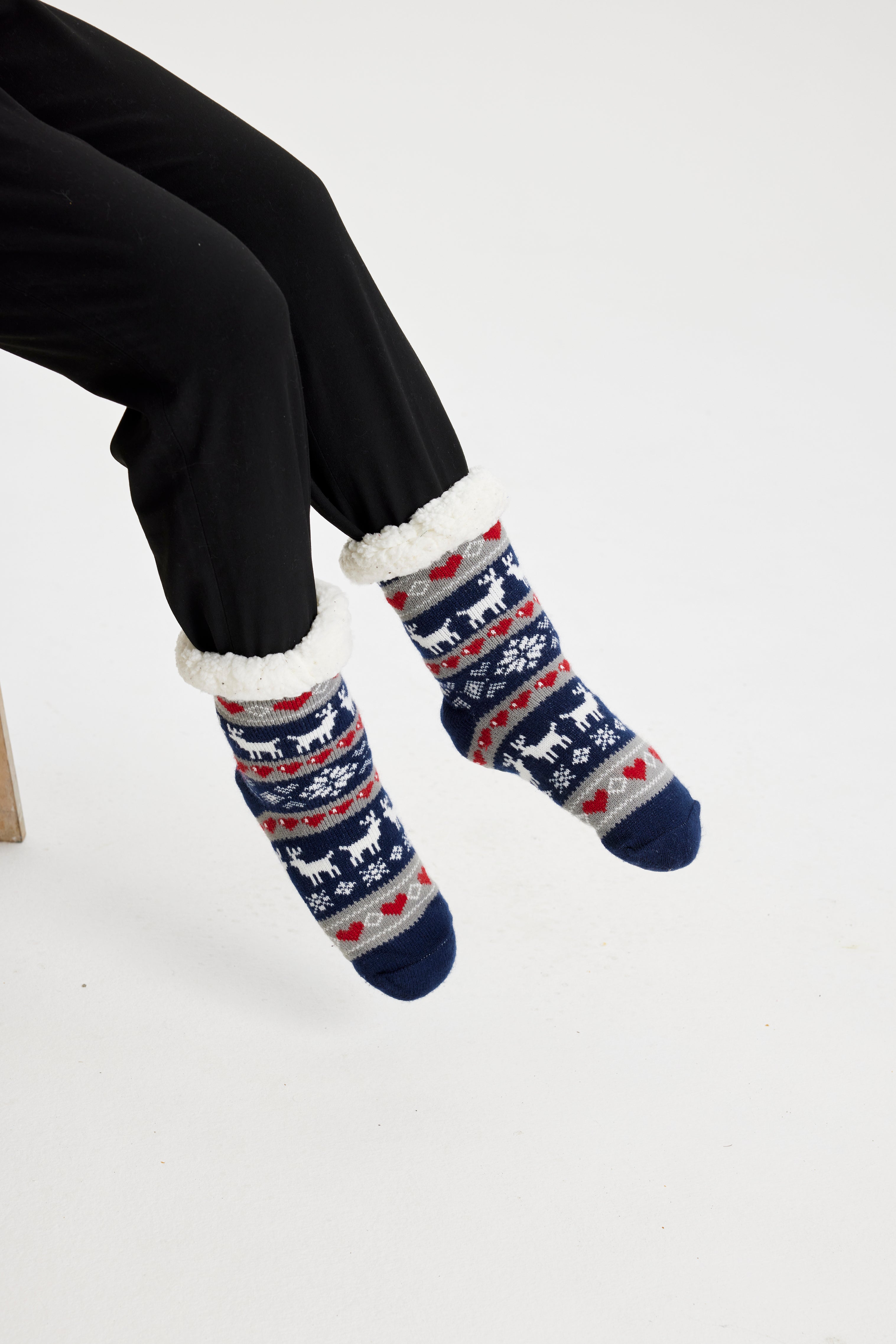 Et par føtter iført blåmønstrede julesokker.