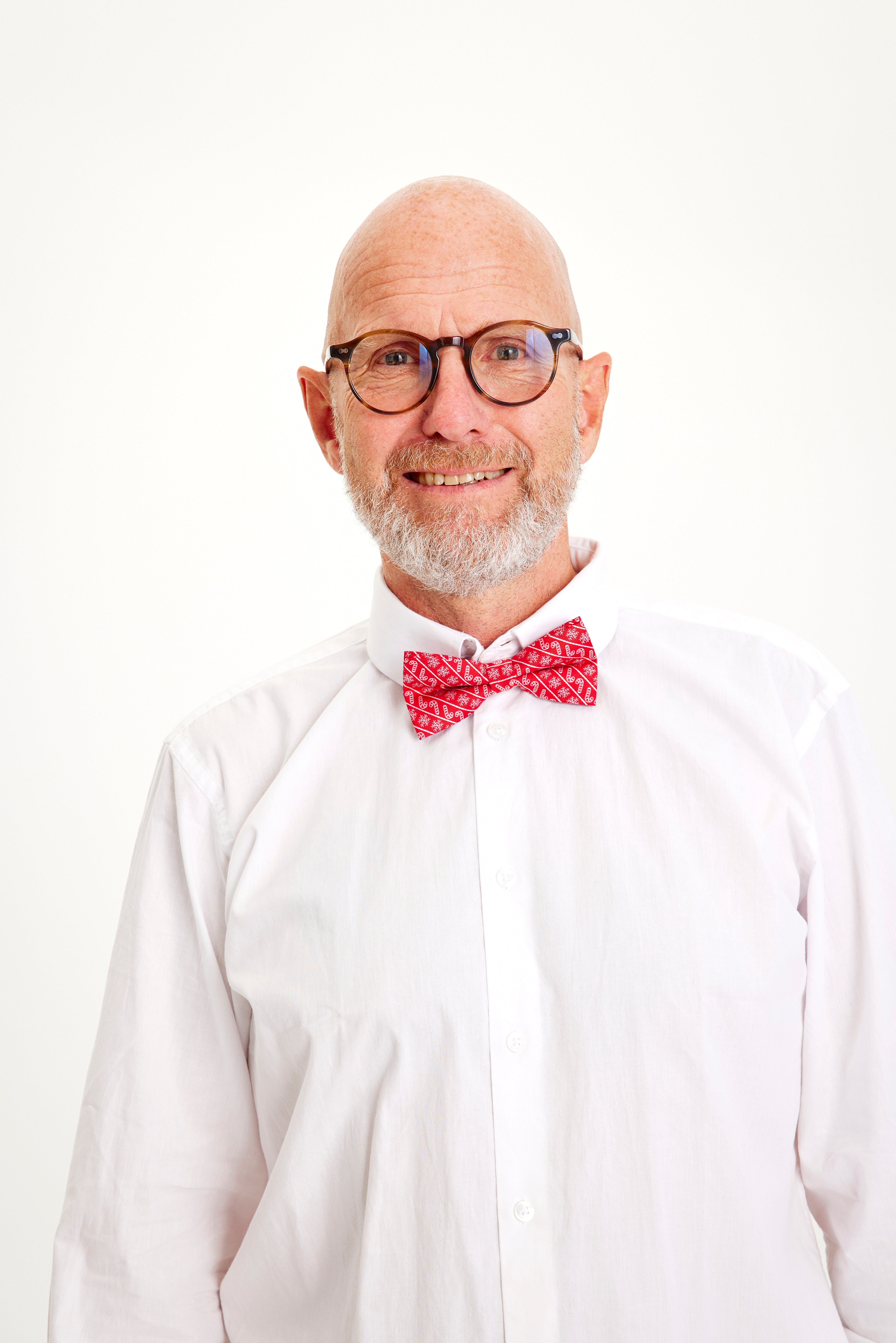 En smilende mann med rød butterfly.