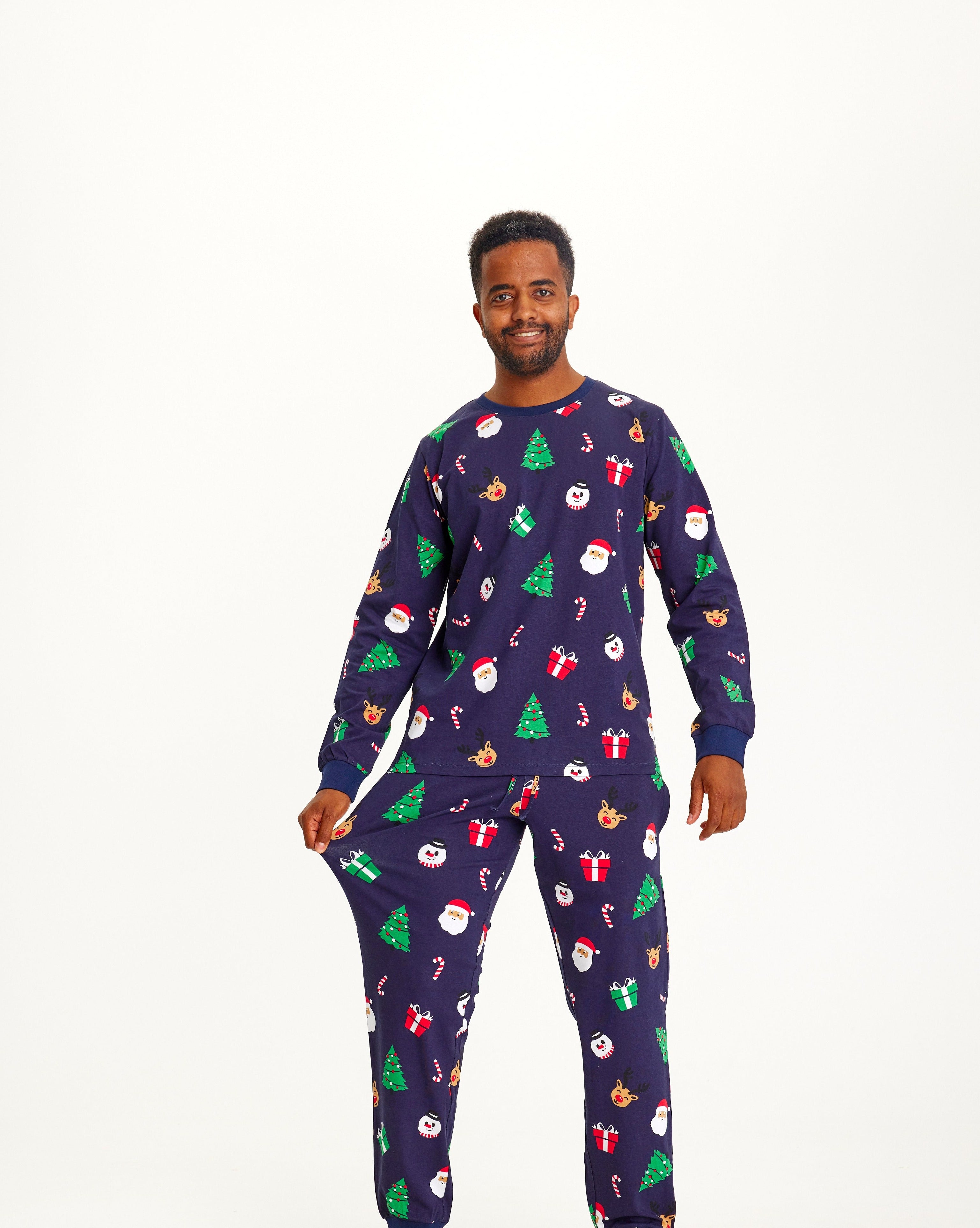 En mann har på seg en blåmønstret julepyjamas.