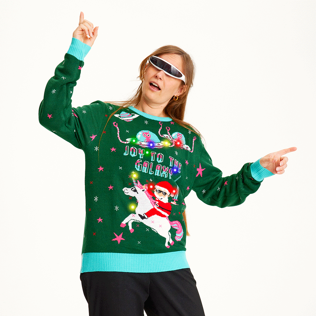 En kvinne med solbriller har på seg en grønn julegenser med sitatet 