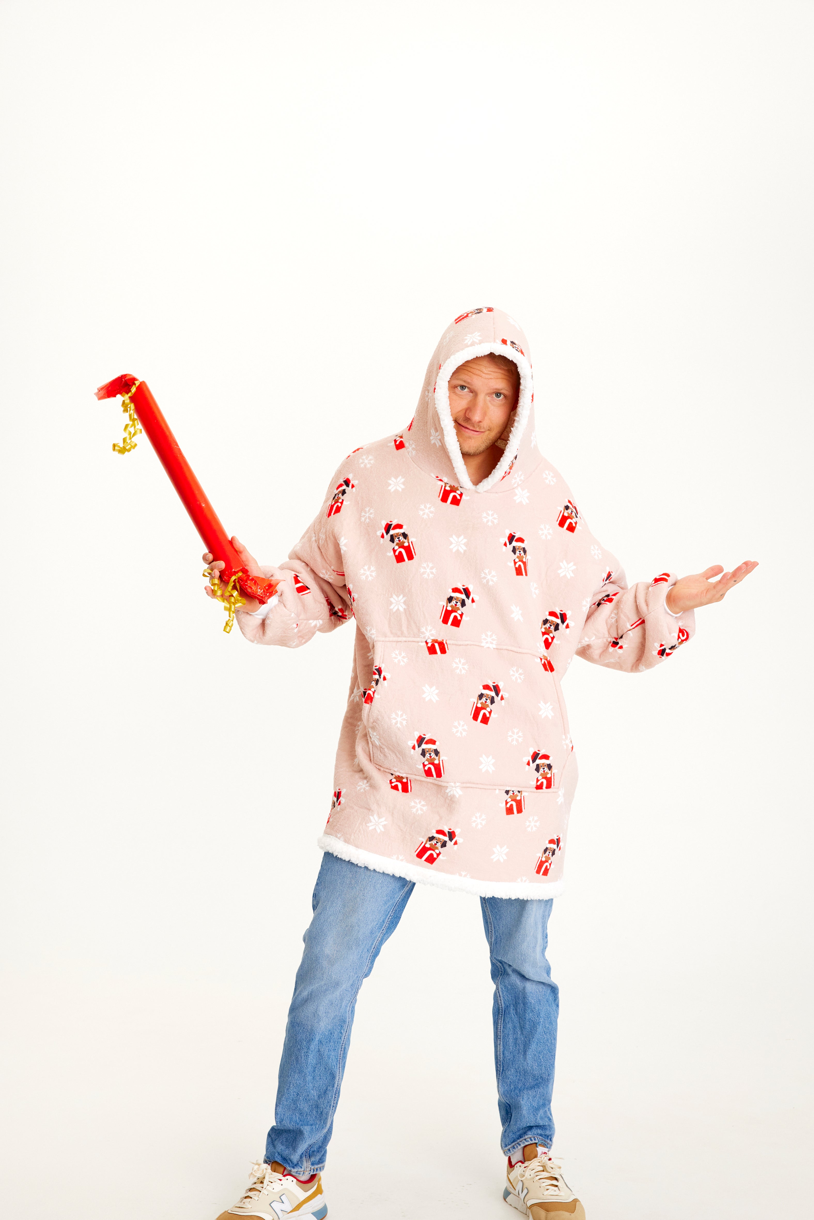 En mann poserer iført en rosa julegenser med hunder på.