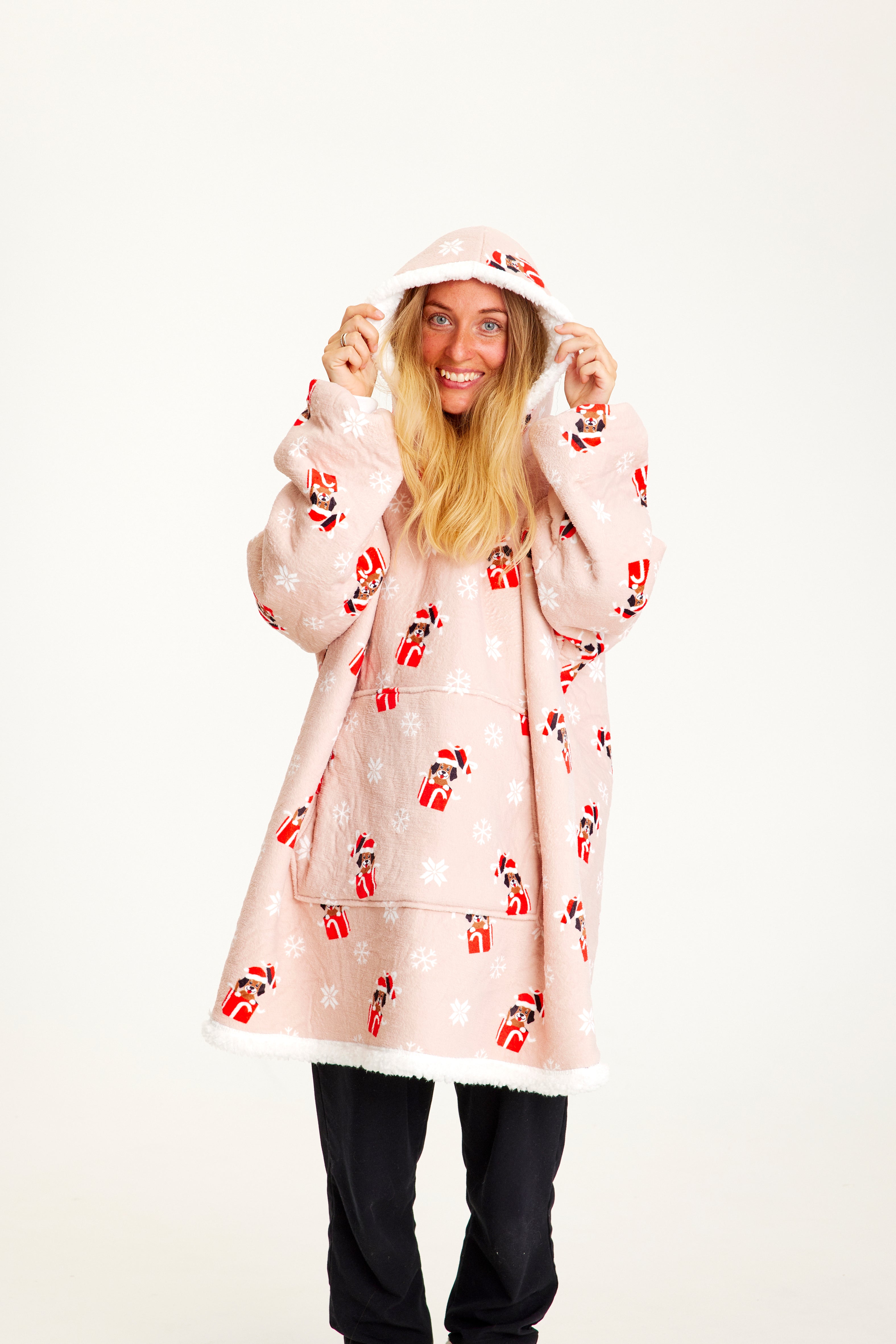 En kvinne med rosa julegenser med hunder på.