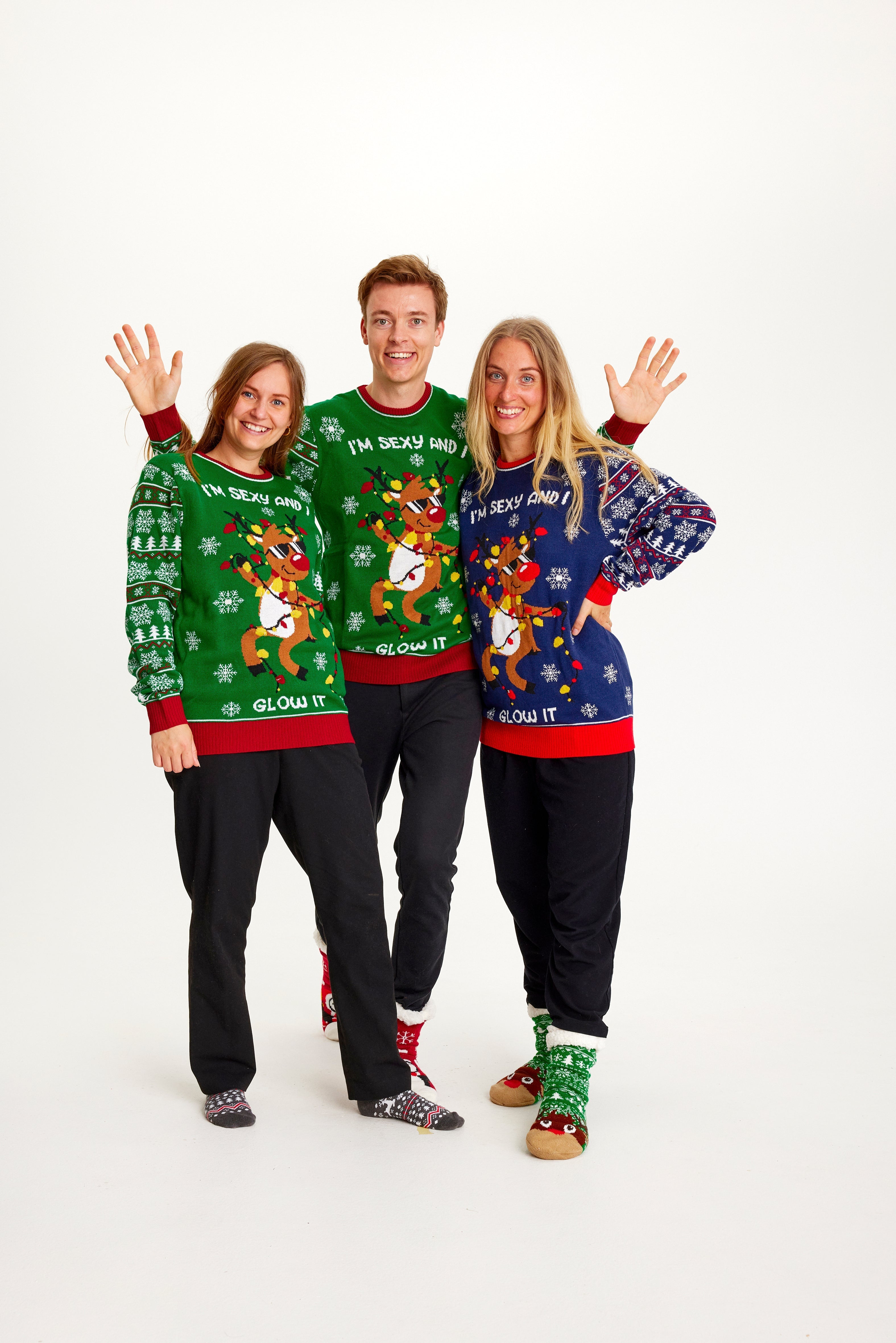 En familie iført julegenser med dansende reinsdyr og lys.