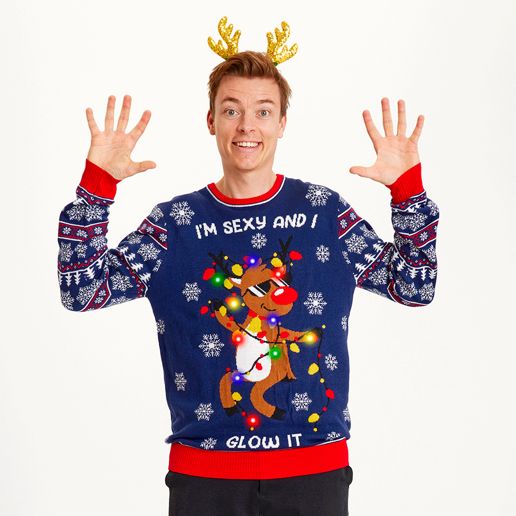 En mann iført julegenser med dansende reinsdyr og lys.