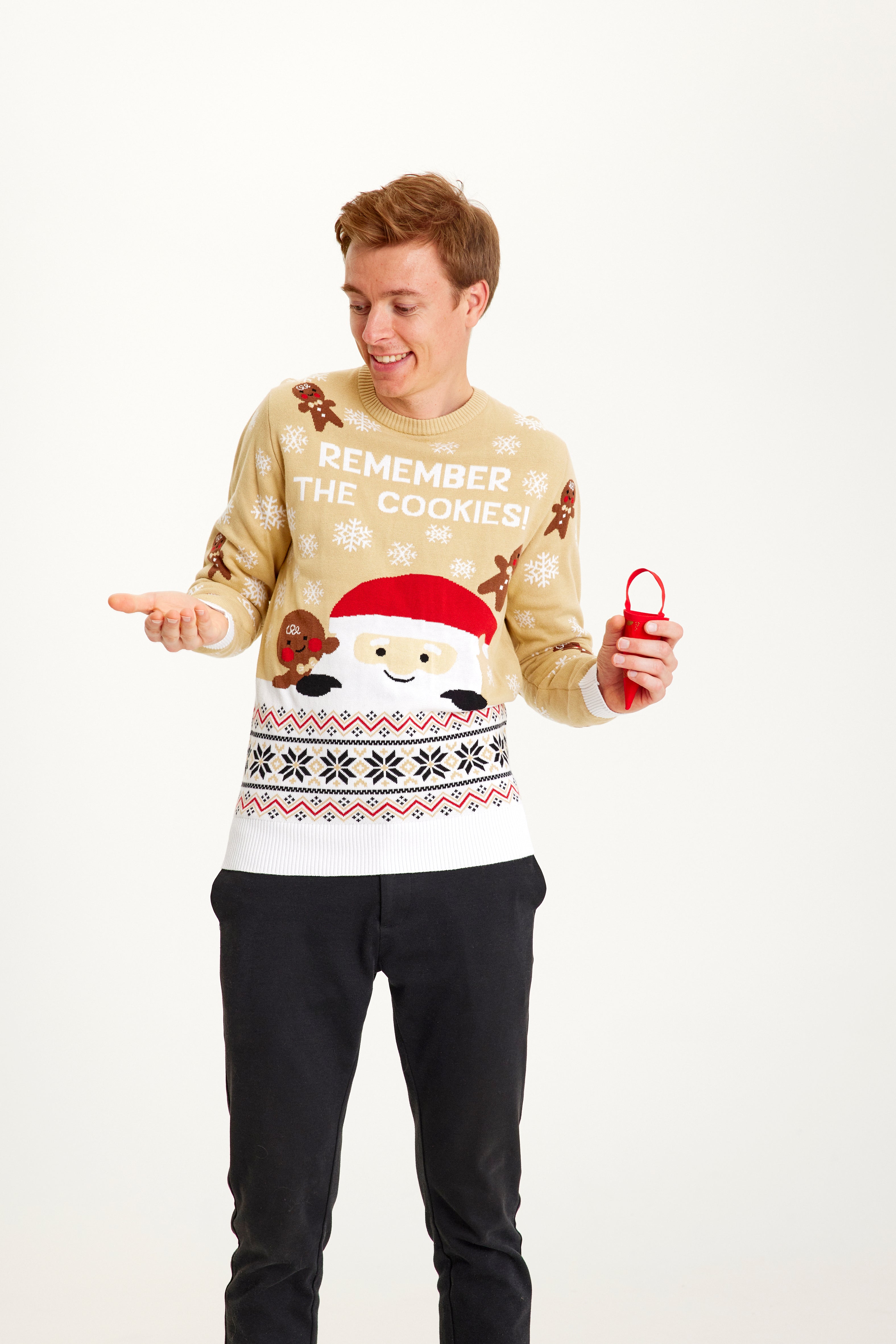 En smilende mann iført en beige julegenser med småkaker.