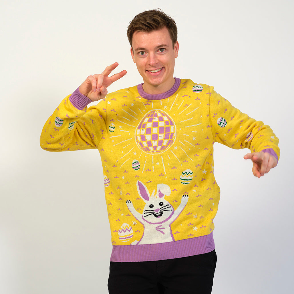 Mann i gul påskegenser med diskokule og kanin.