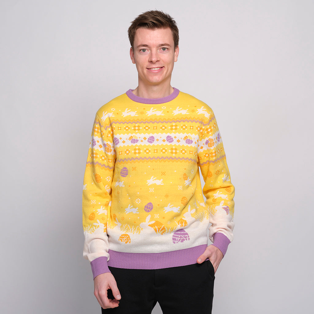 En smilende mann har på seg en gul påskegenser med harer på.