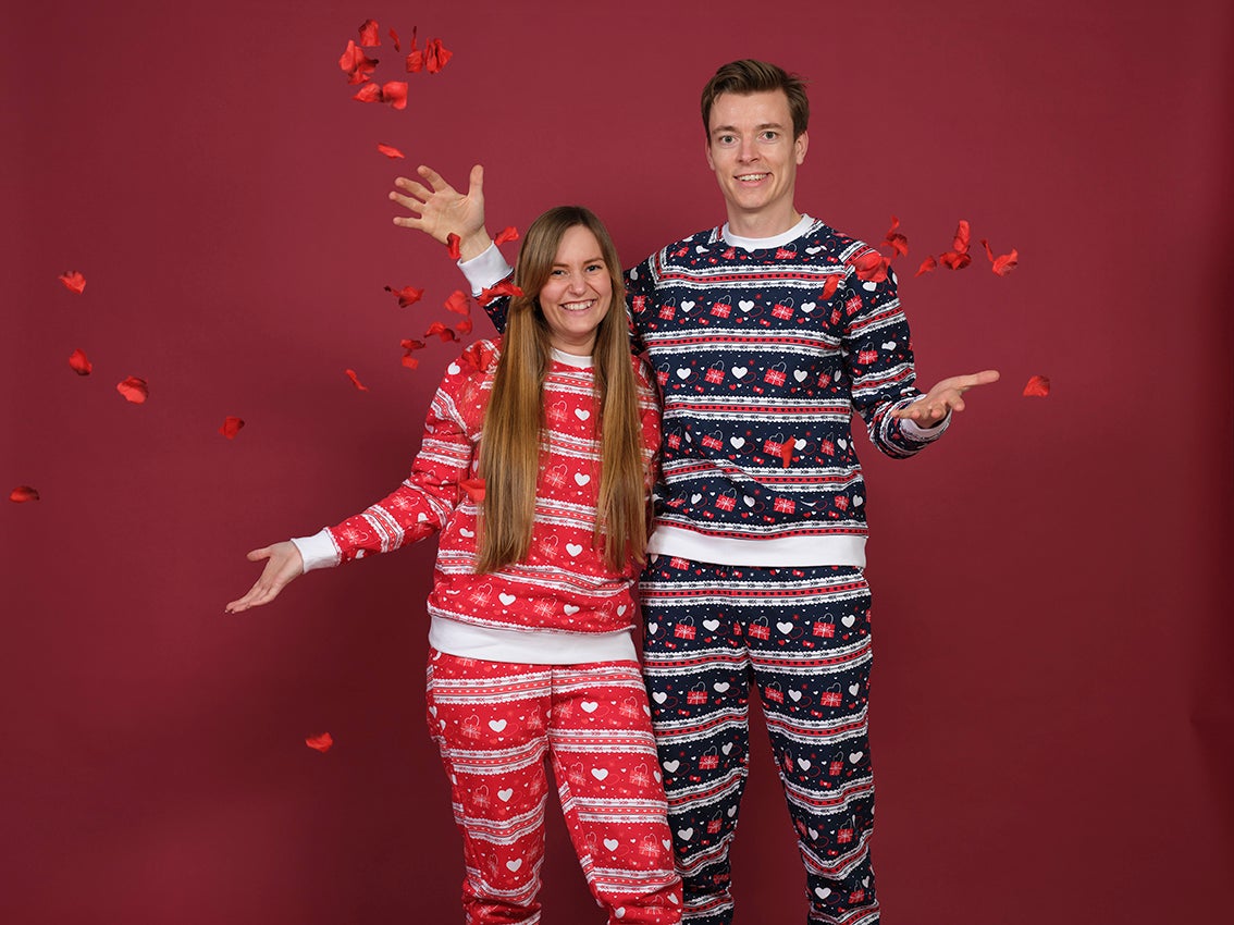 Et par poserer sammen i hvert sitt valentinsett med hjerter på.