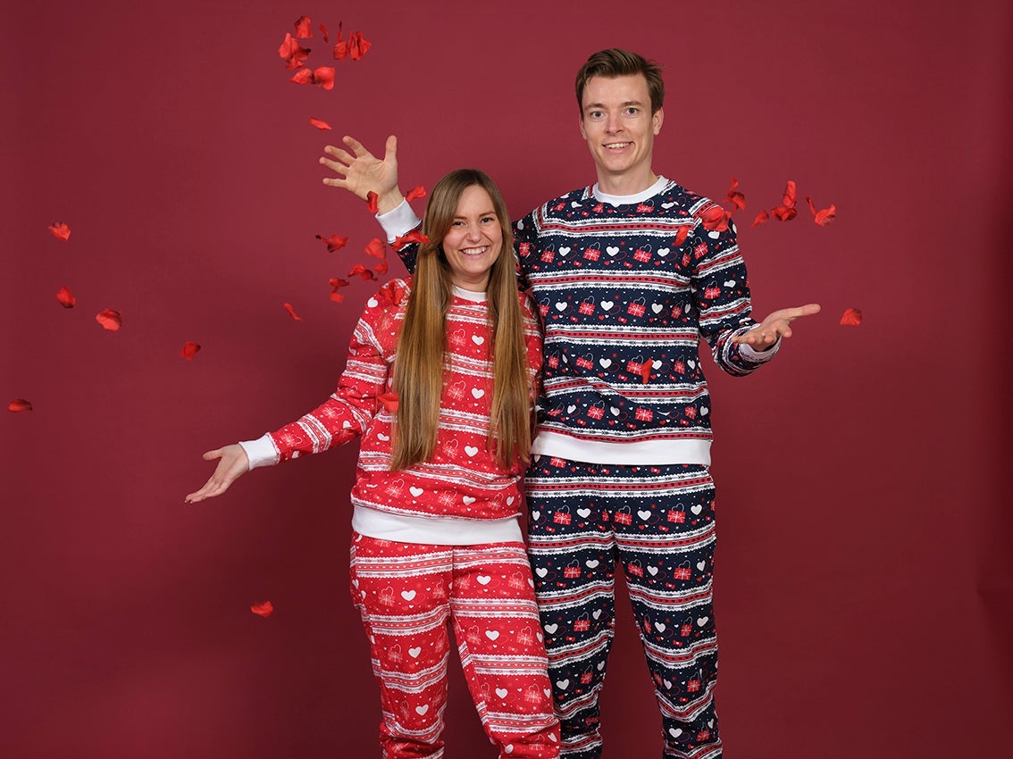 Et par poserer sammen i hvert sitt valentinsett med hjerter på.