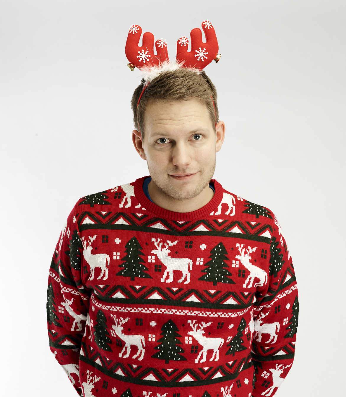 En poserende mann har på seg et rødt hårbånd som ser ut som et reinsdyrgevir.